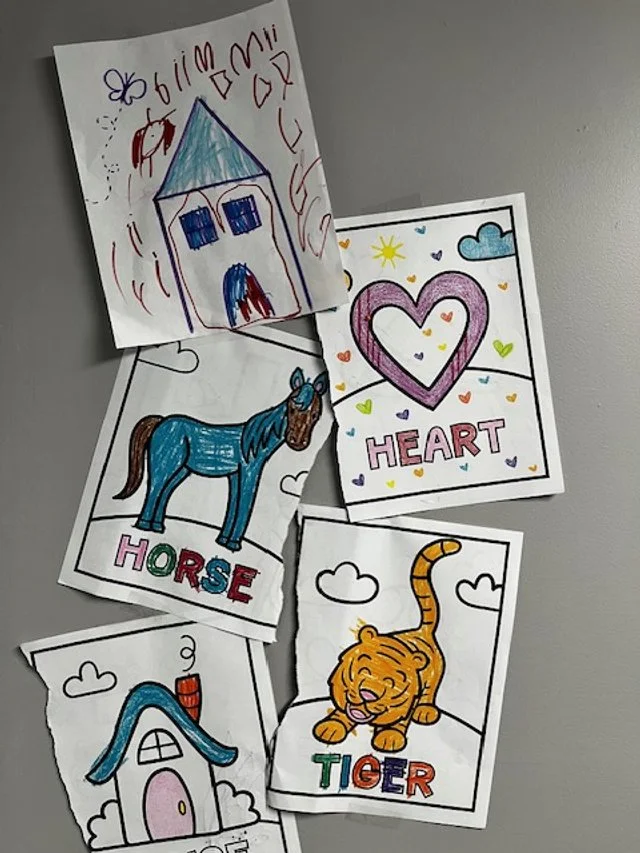 Kids’ artworks hanging on the wall in Kayla Pelphrey’s office.