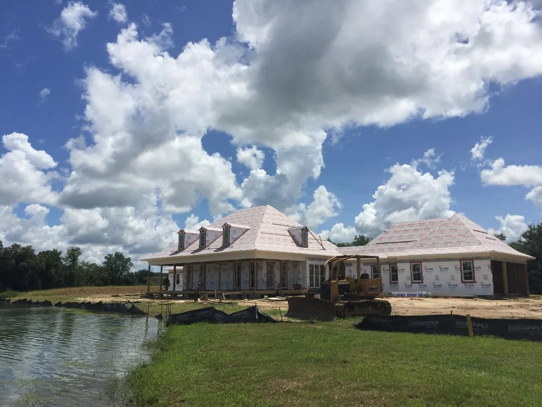 The acadian-style home is situated to follow the curve of the pond.