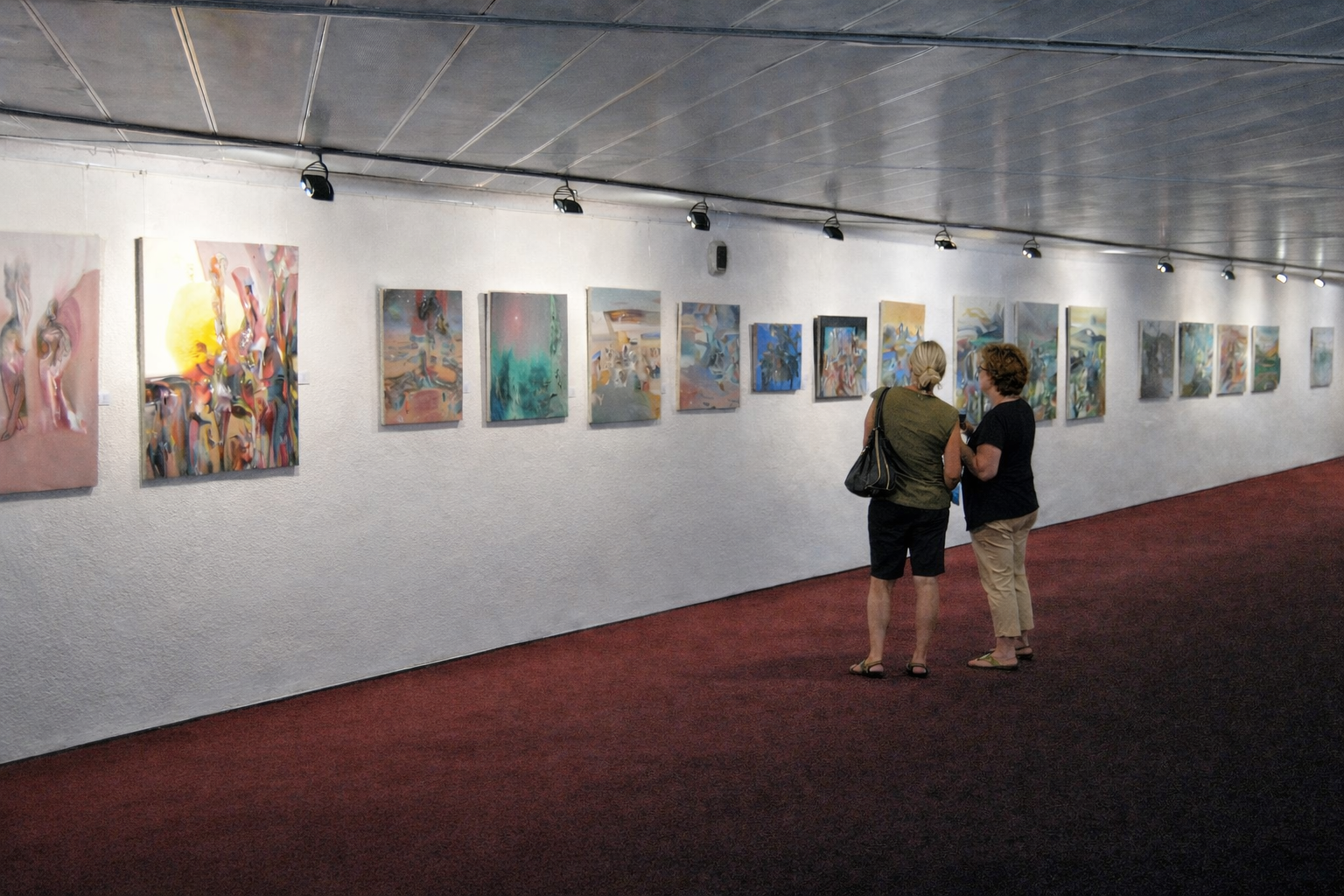 Two visitors viewing Alexey Adonin’s oil paintings at Reflection, his solo exhibition at Jerusalem Theater’s Balcony Gallery, 2011.