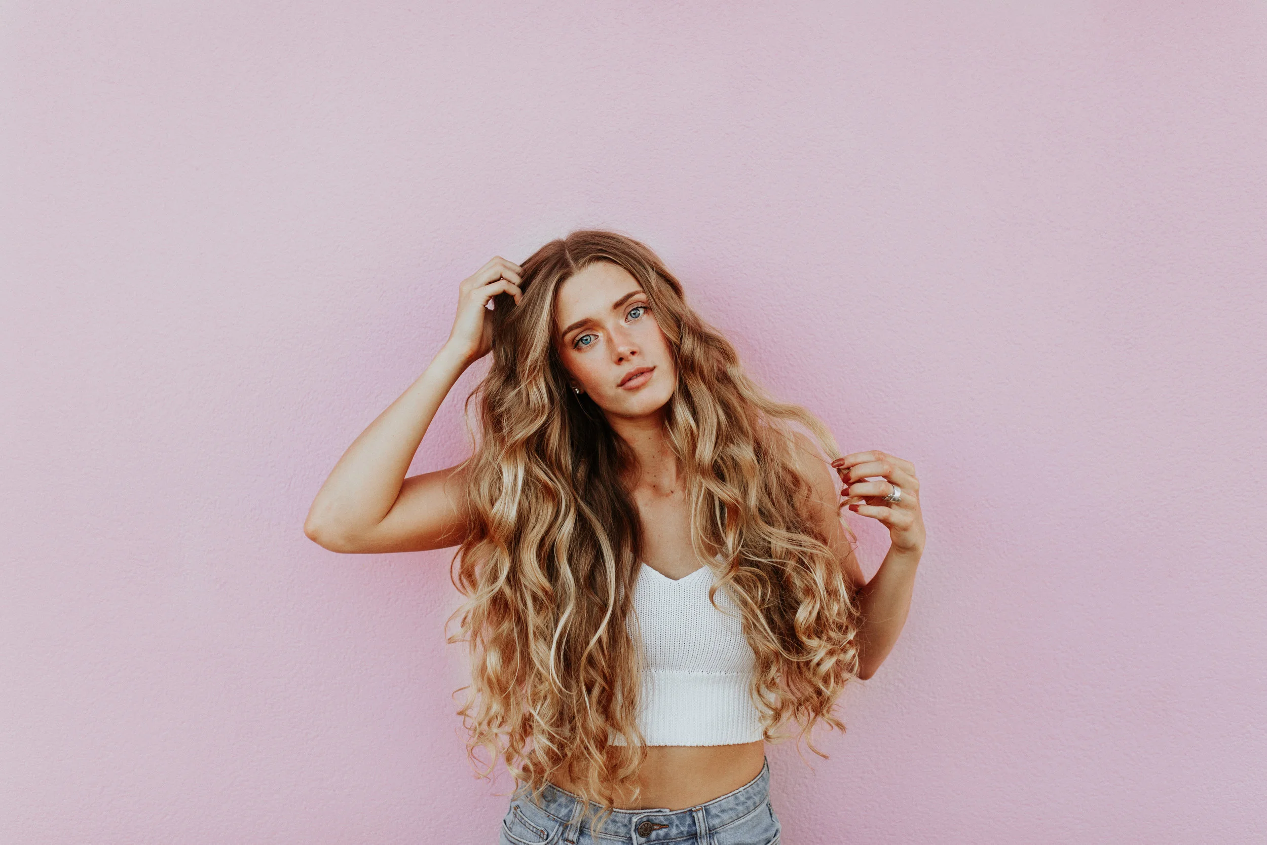 girl with blonde hair on a pink background
