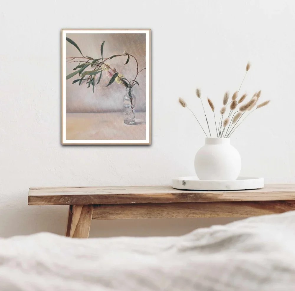 how a paper print of Lets Linger Here looks framed in oak with a fresh white border between print and frame hung above a rustic wooden bench with soft linens.