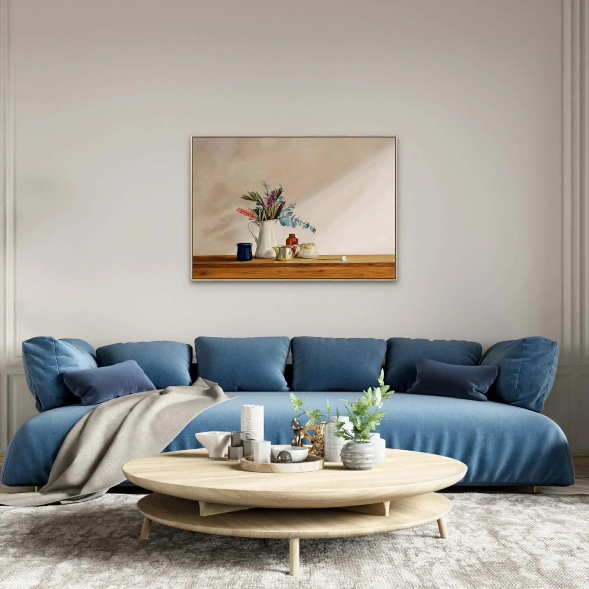 Settled print in a living room above a blue couch that blends well with the eucalyptus leaves in the still life