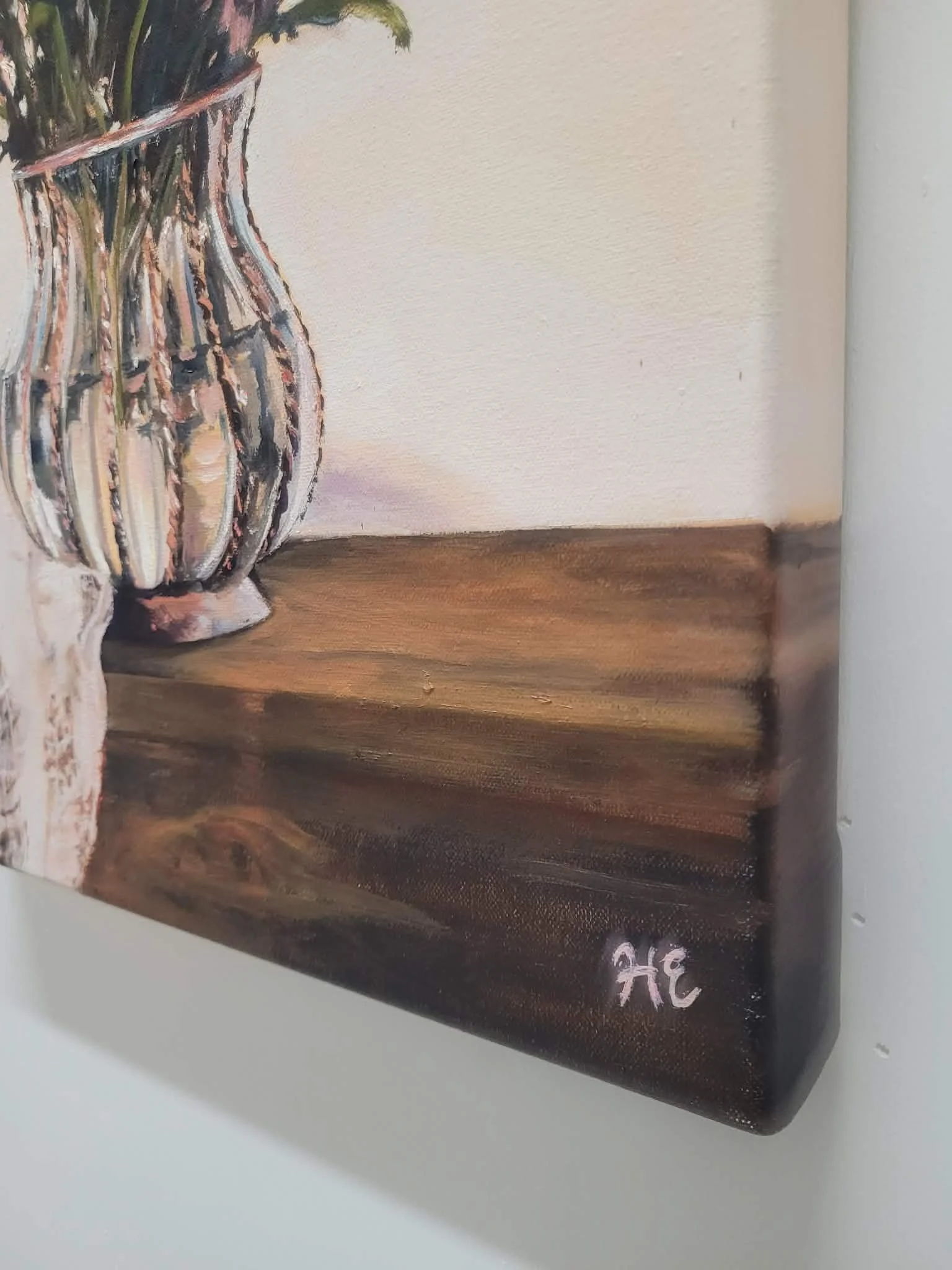 View of the painted stretched canvas edges of original oil painting of soft pink chrysanthemums arranged in a clear glass vase on a timber table by Australian artist Heidi Emma.