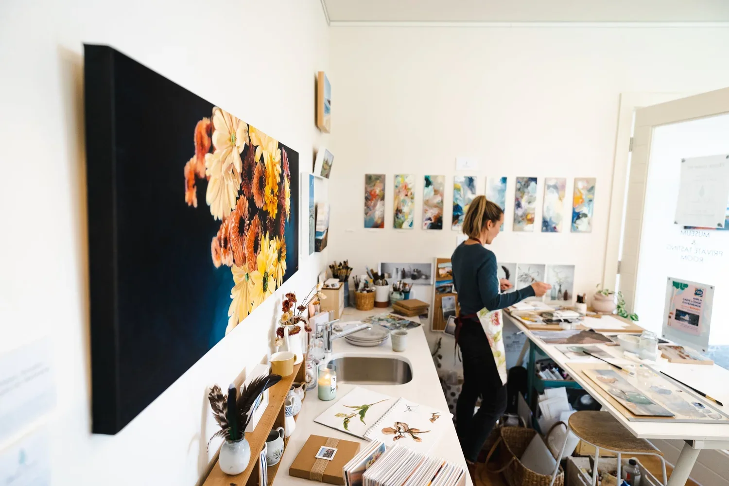 moody blooms on a white wall in Heidi Emmas studio at Flametree Winery.webp