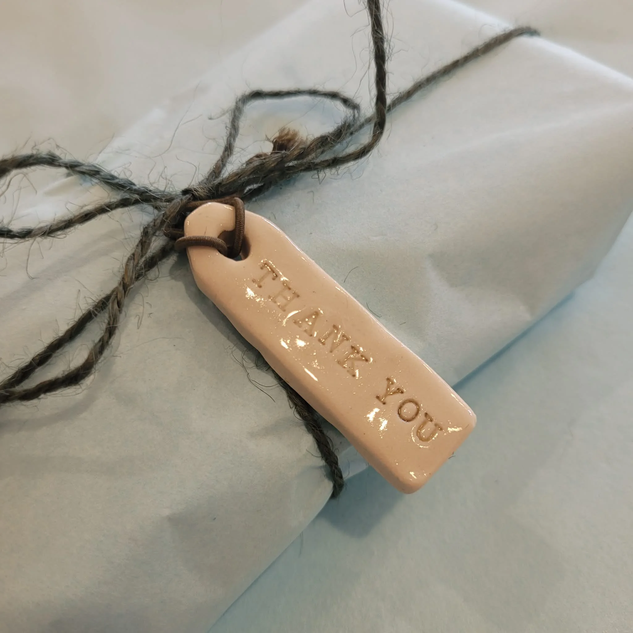 Ceramic gift tags by My Earthy Life are beige neutral coloured and glossy with fine classic olive coloured print and finish off the wrapping of gifts beautifully