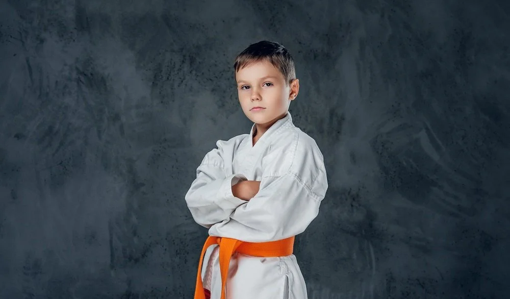preschooler-boy-dressed-white-karate-kimono-with-orange-belt.jpg