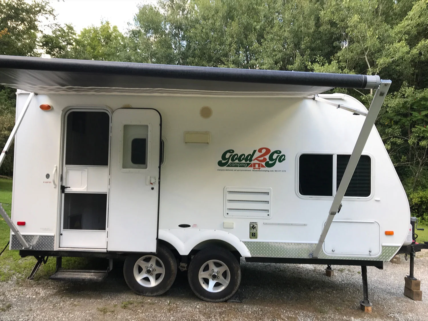 An exterior shot of the Huxley camper trailer with the awning extended.