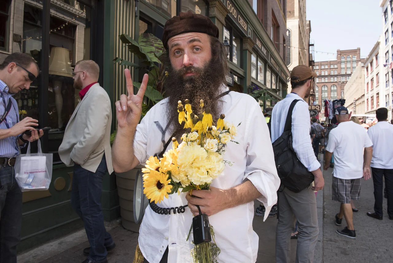  Rod Webber, of Boston, Mass., spreads his message of peace by passing out flowers near the entrance to the Quicken Loans Arena in Cleveland.  “I’m with peace, and I’m trying to spread peace, so I’ve come to a lot of conventions and rallies to pass t