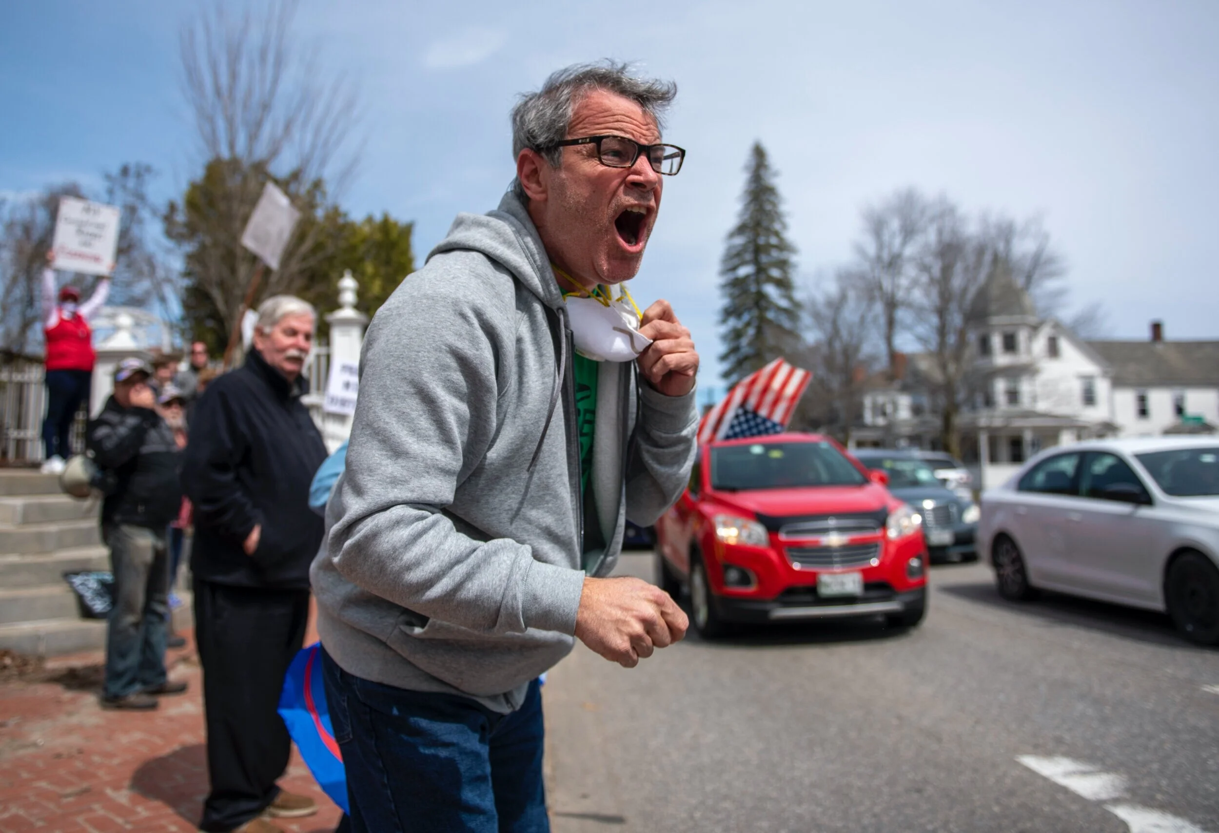  A protester yells at a passing car that had a ‘You Suck!’ sign in the window during a “Re-Open Maine” protest outside of the Governor’s house in Augusta, Maine on Monday, April 20, 2020. The protests coincided with other protests across the country 