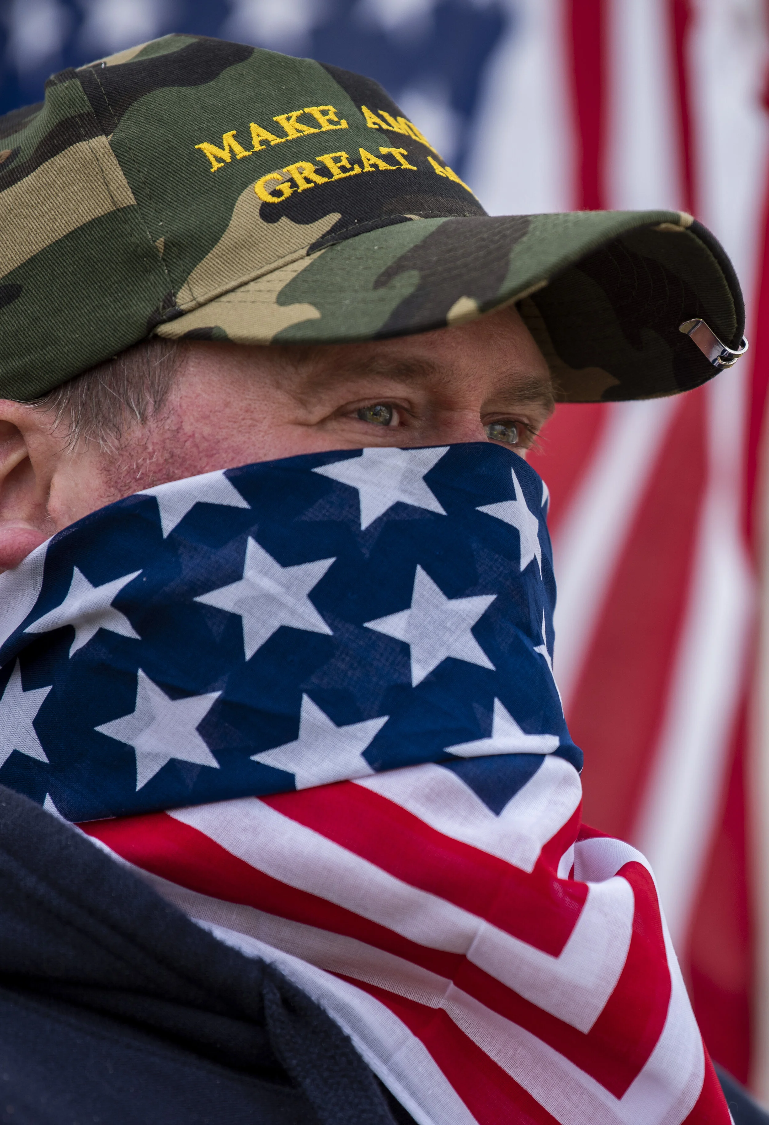  A protester holds an American flag while at a “Re-Open Maine” protest outside of the Governor’s house in Augusta, Maine on Monday, April 20, 2020. The protests coincided with other protests across the country to advocate that governors re-open the e
