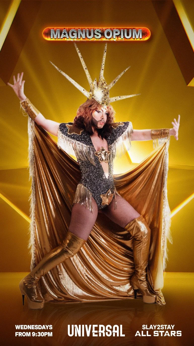A performer dressed in a gold and black costume with thigh-high gold boots, a star-shaped crown, and cape poses dramatically on stage in front of a yellow background with a sign that reads "Magnus Opium" and promotional text for a show featuring Universal and Slay2Stay All Stars.