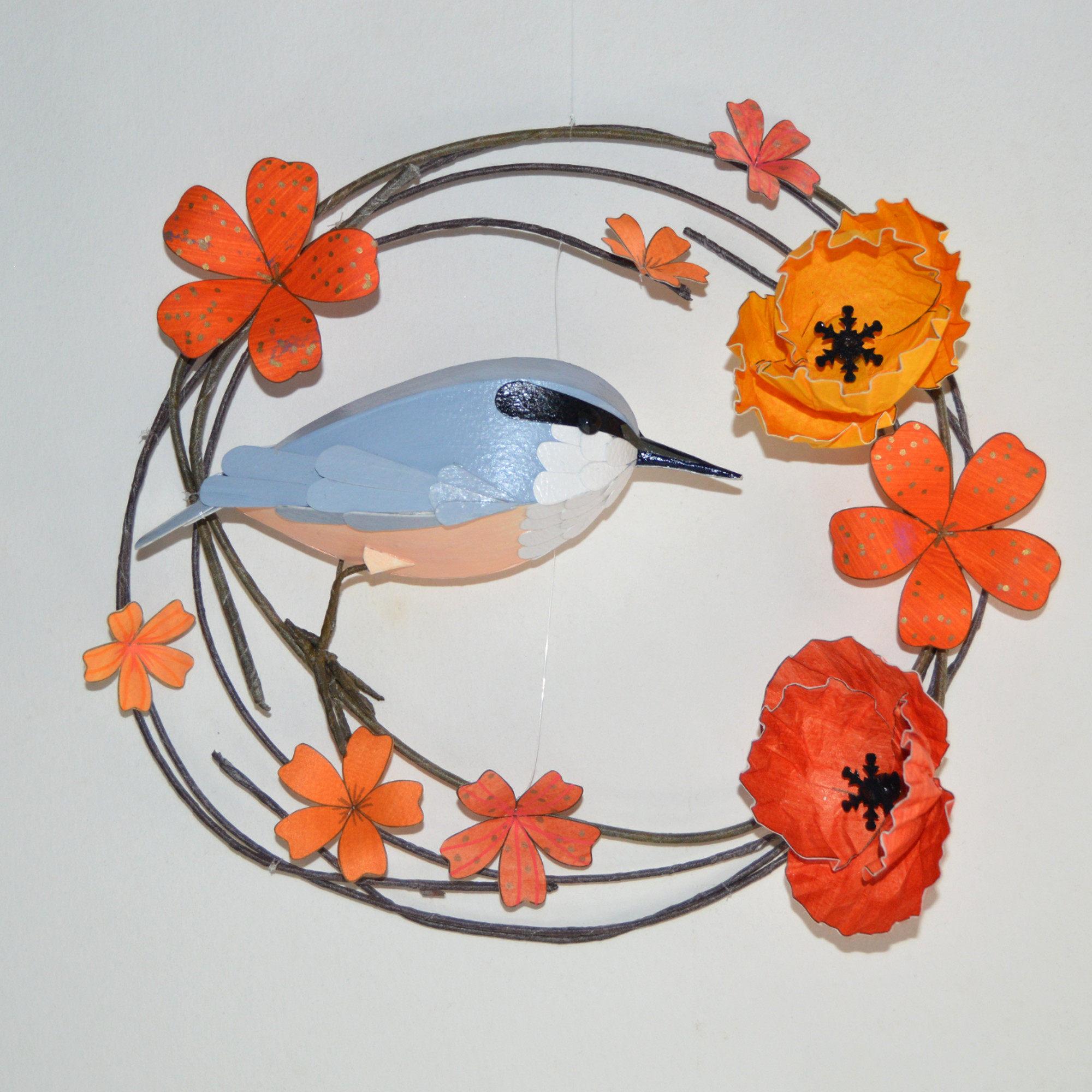 Stevie the nuthatch on a hoop of orange flowers