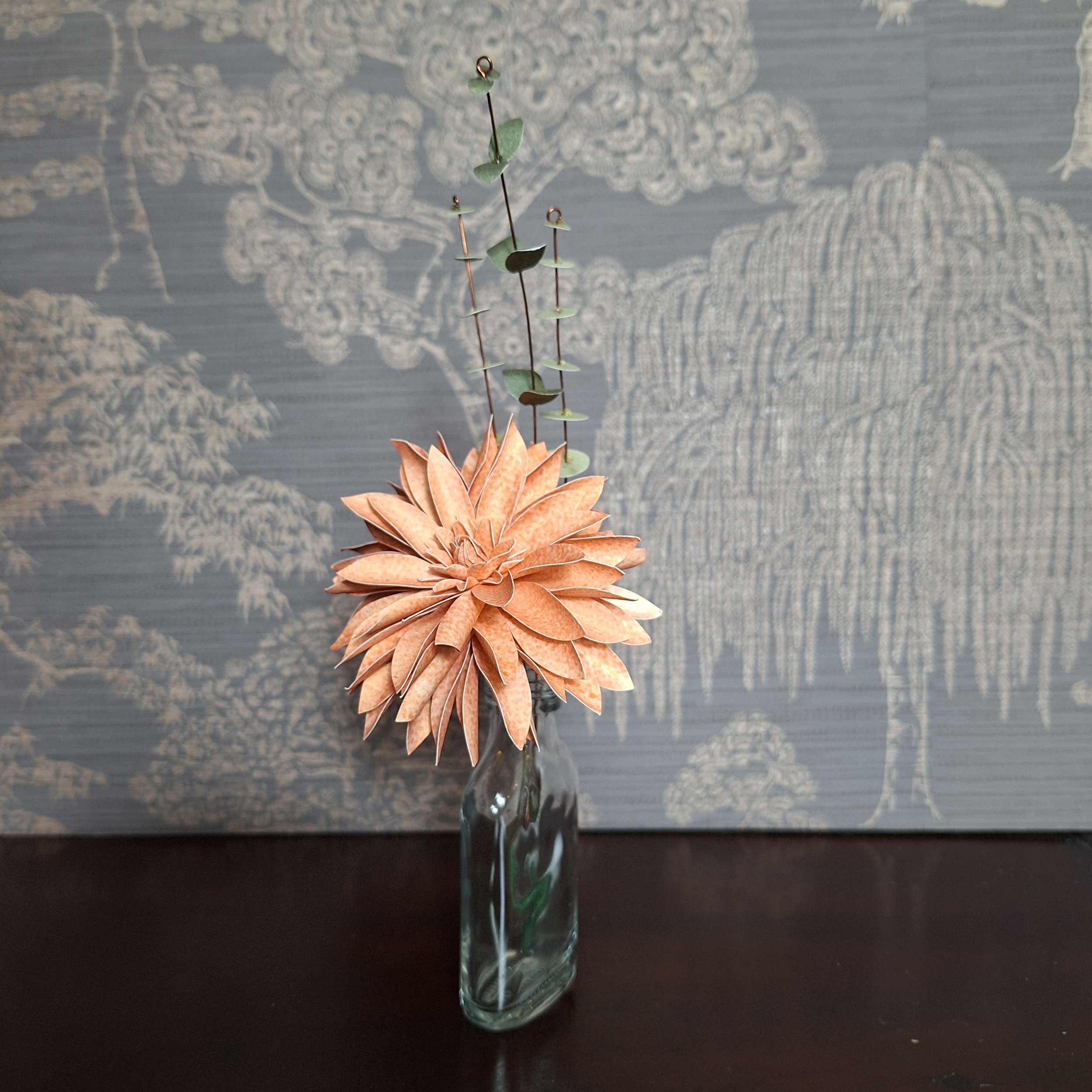 handmade paper sculpture of a dahlia flower in peach
