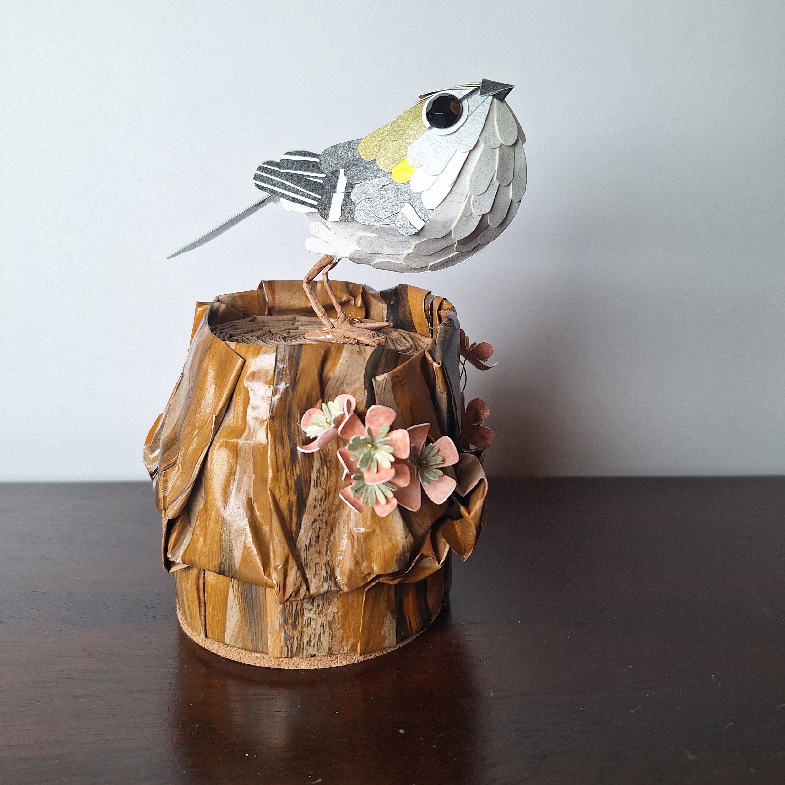 garden bird home décor, featuring a goldcrest on a tree stump adorned with tree blossom flowers