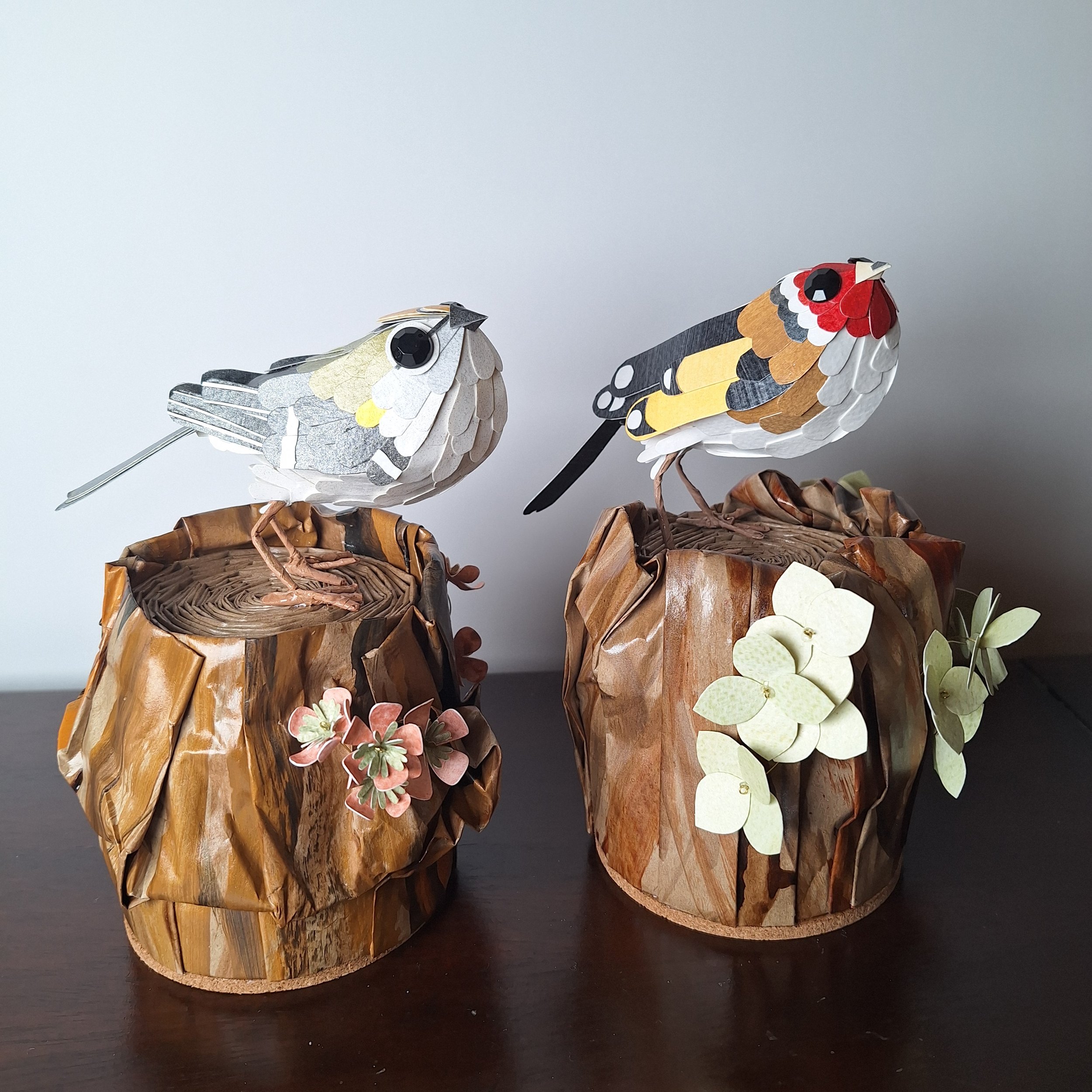 garden bird home décor, featuring a goldcrest on a tree stump and a goldfinch on a tree stump.