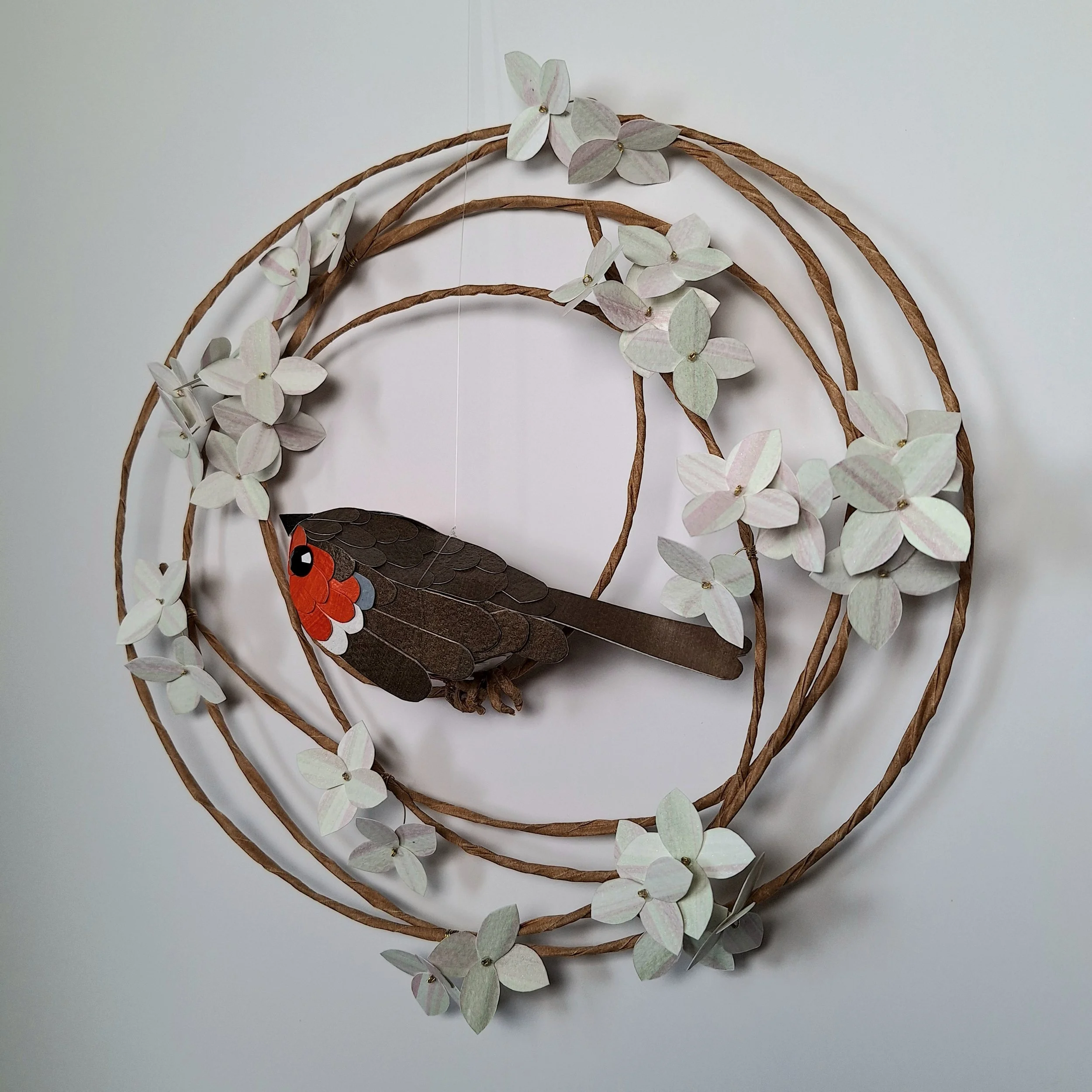 side view of the floral wreath and robin, showing his brown tail feathers.