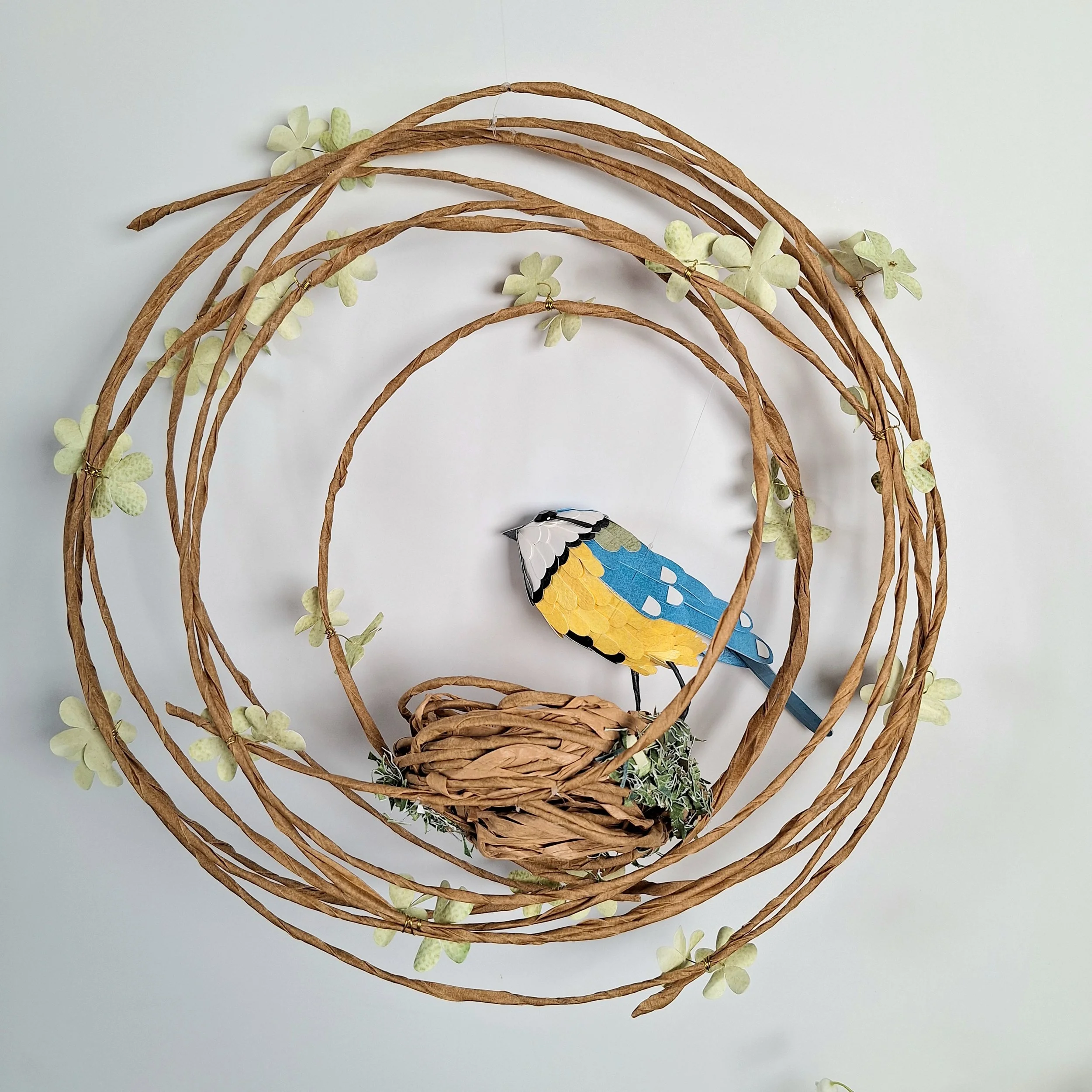 Back view of the bird sculpture and floral wreath.