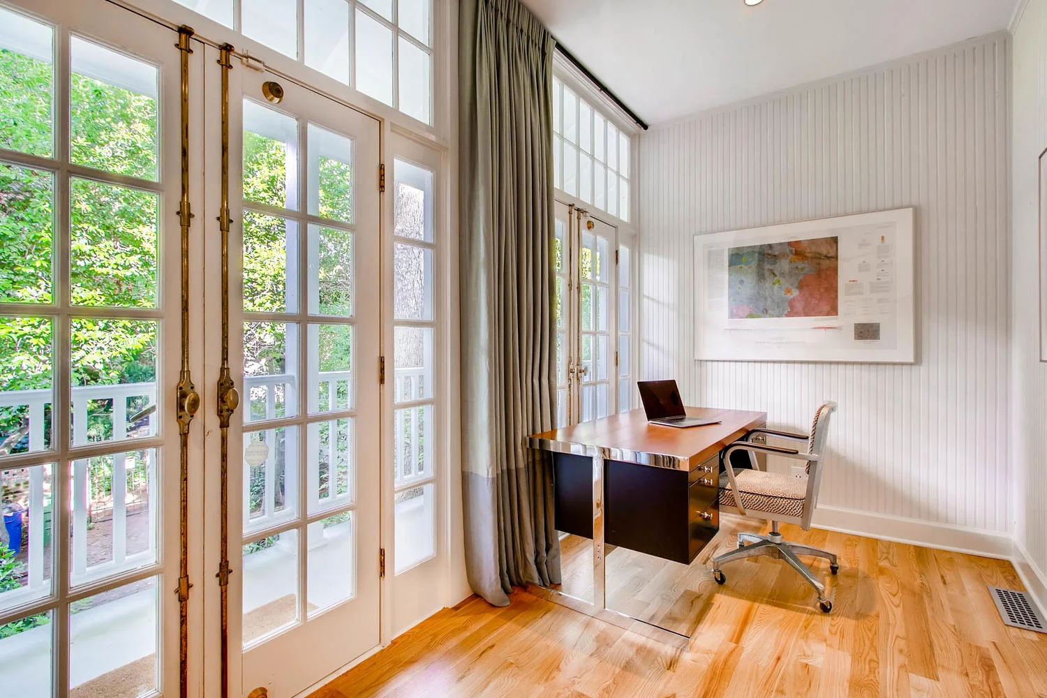 SUNROOM WITH DESK LOOKING OUT TOWARDS THE BACKYARD