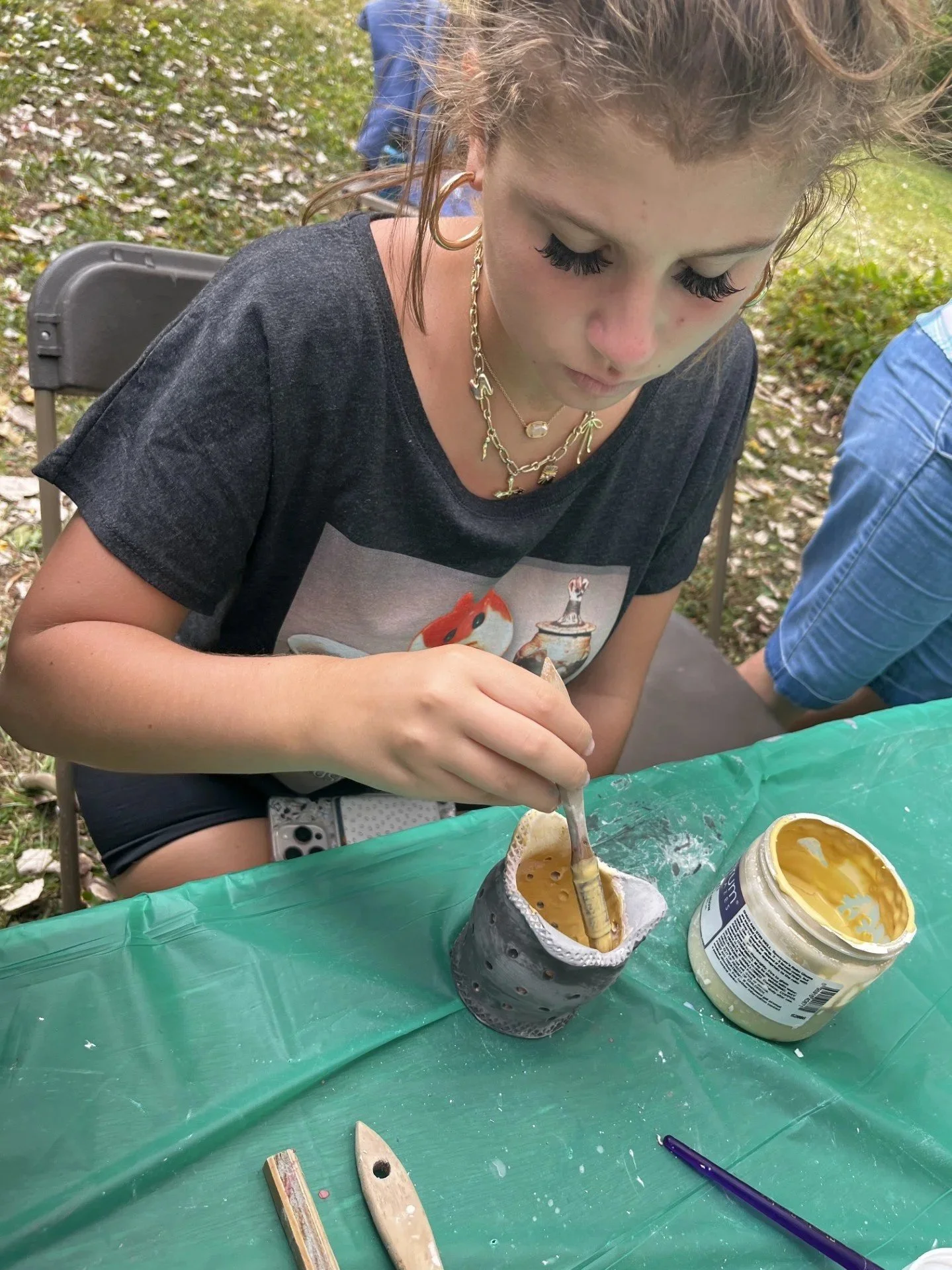This artist is glazing a pot for the Raku fire