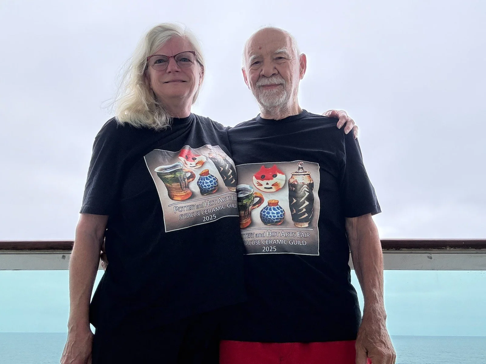 Paul and Cheryl wearing pottery fair shirts on their cruise