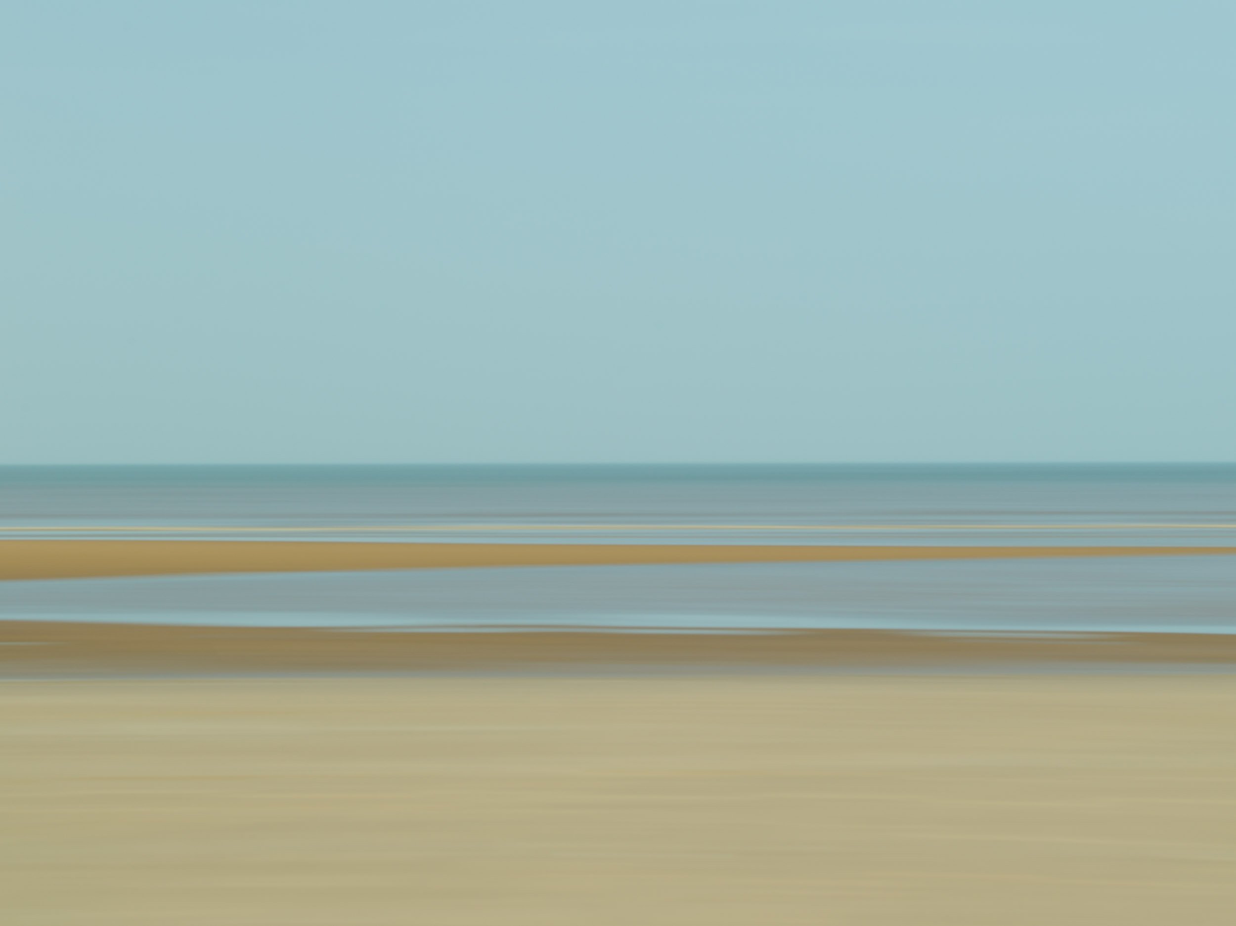 Abstract blurred motion image with horizontal streaks in shades of blue, green, brown, and beige.