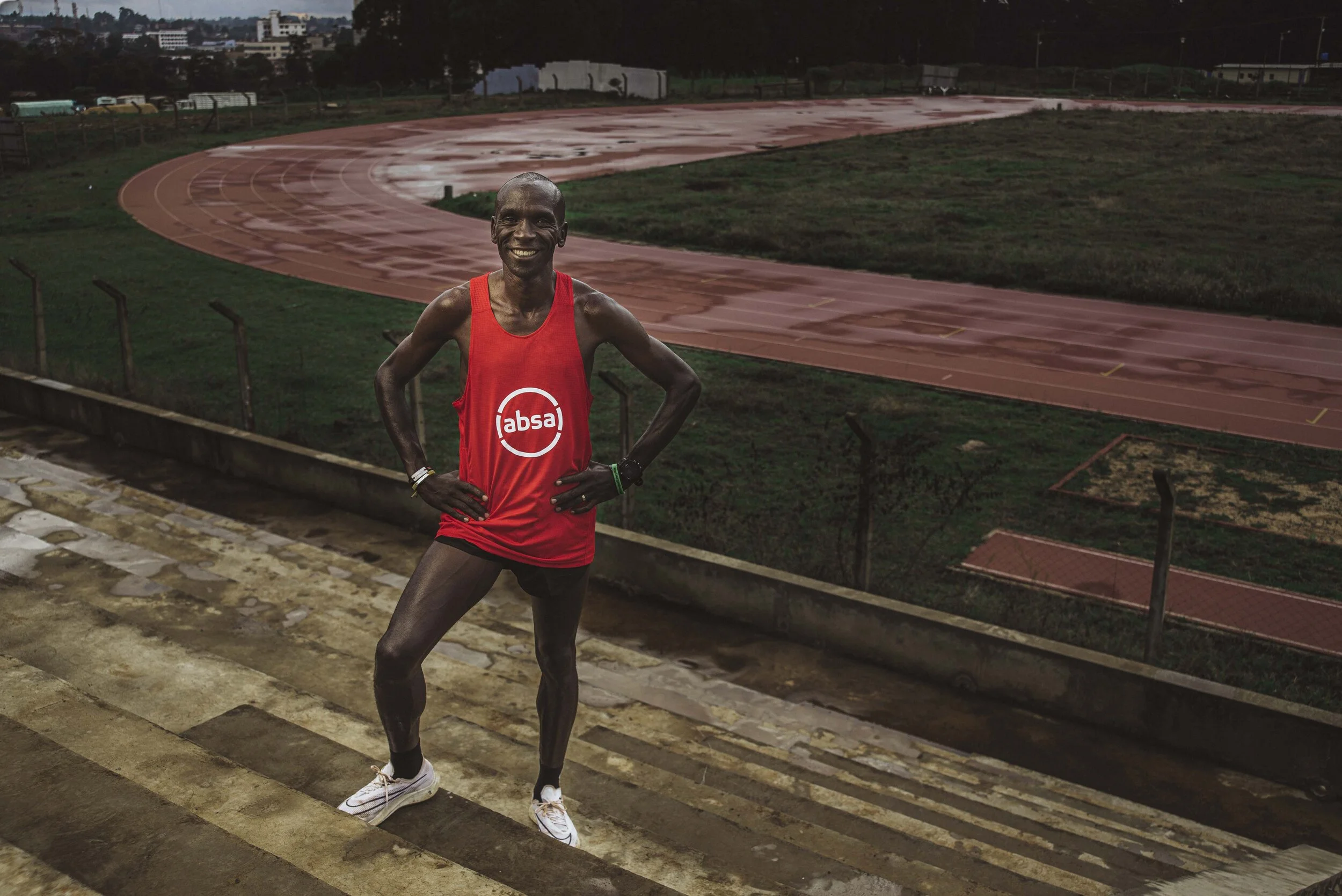 Athlete on stadium steps with running track in background