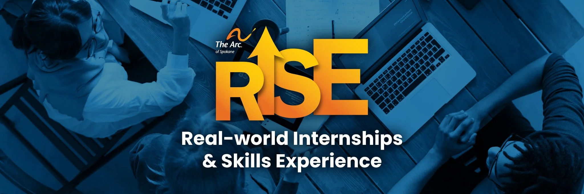 The Arc of Spokane and RISE program logos overlay a blue duotone image of young adults collaborating together at a desk with laptops. The words "Real-world Internships and Skills Experience" is underneath the logos.