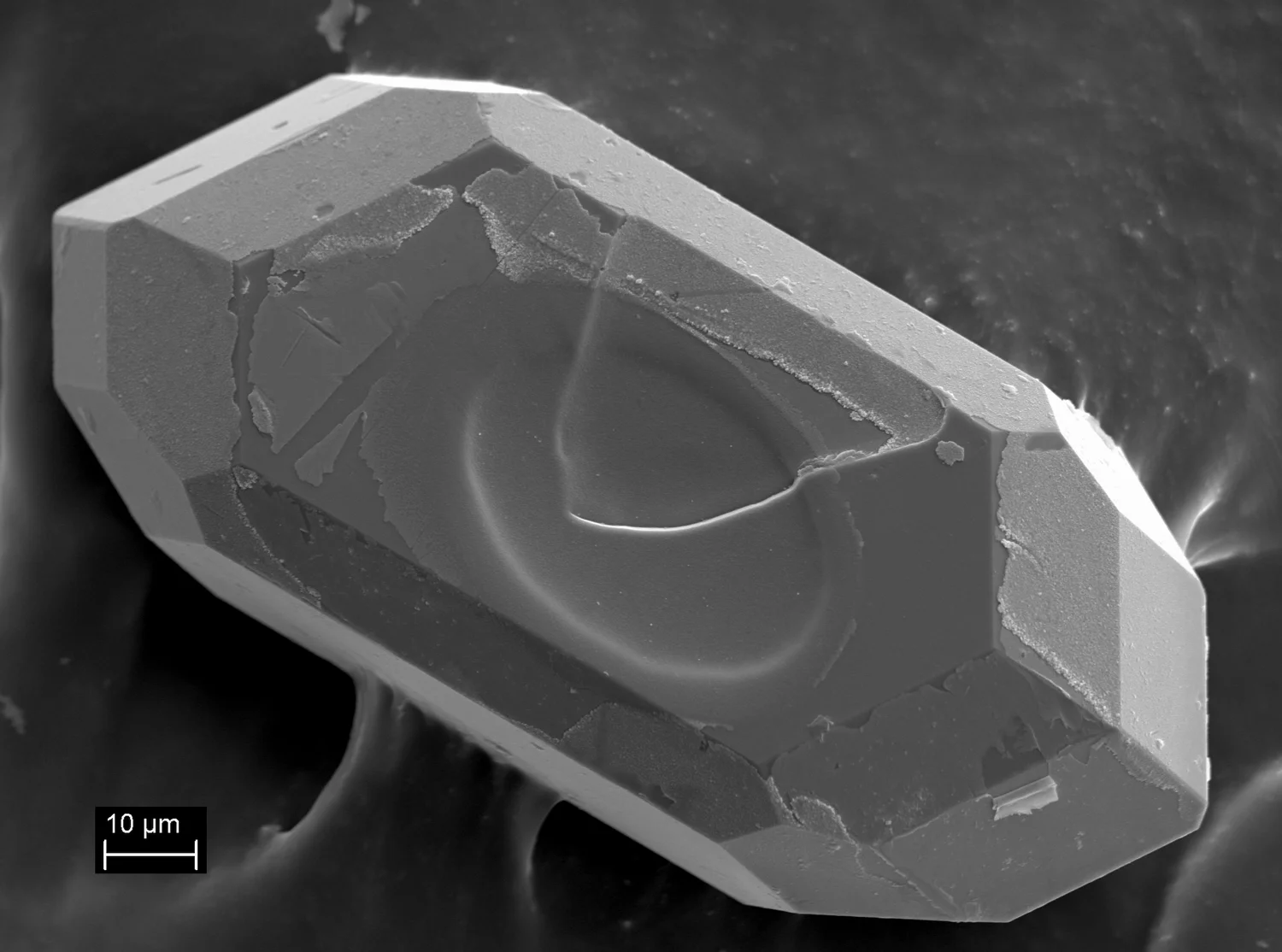A photomicrograph showing one of the tiny zircon mineral grains that was extracted from the volcanic ash layer containing the Kula footprints, and analysed back at the JDLC laboratory in Perth. Image: Dr Martin Danišík and Elaine Miller .