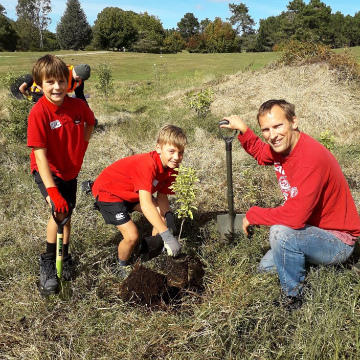 Students from Taupo Primary work alongside of Cheal Consultants staff member, planting natives at Spa Park as part of a company community service project.