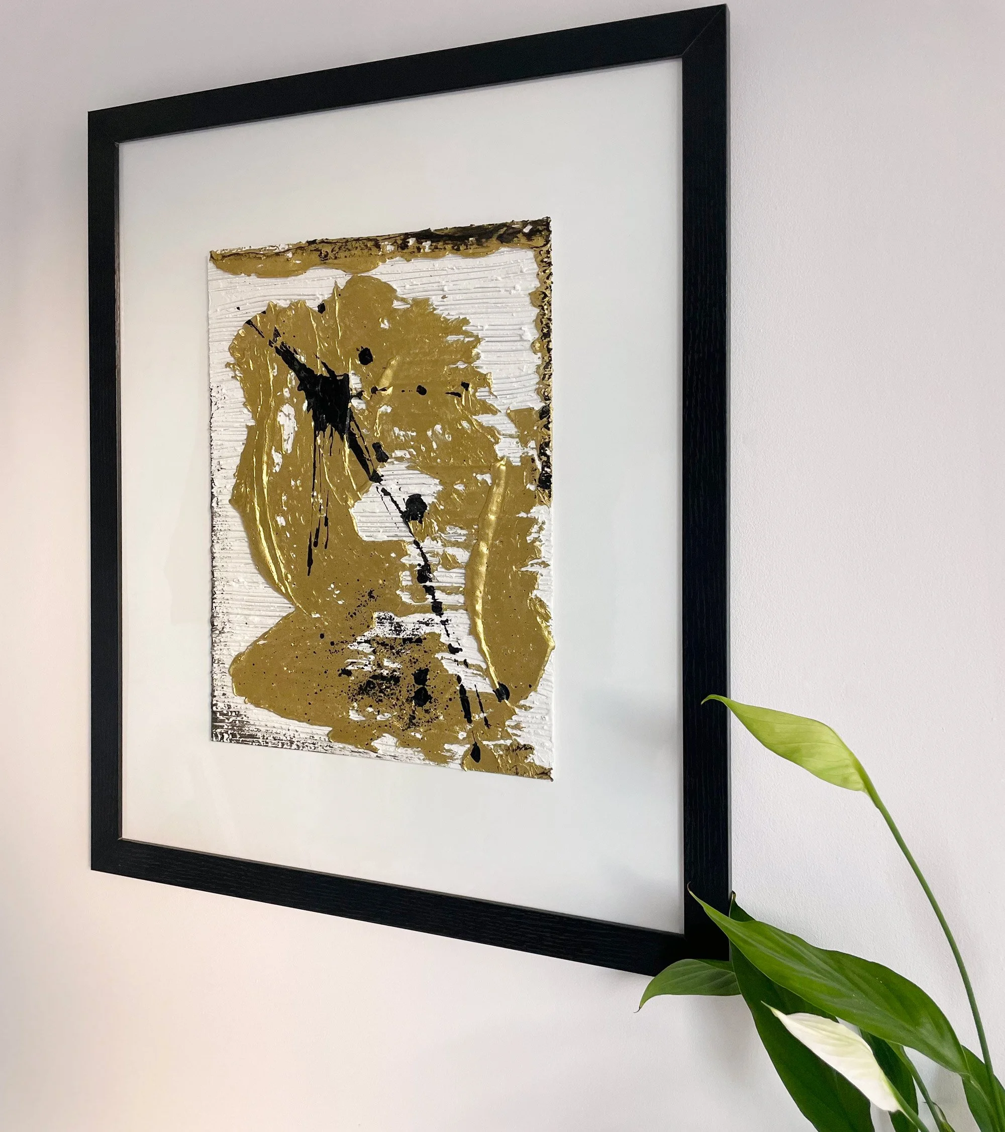 Modern abstract art with gold texture and black streaks.