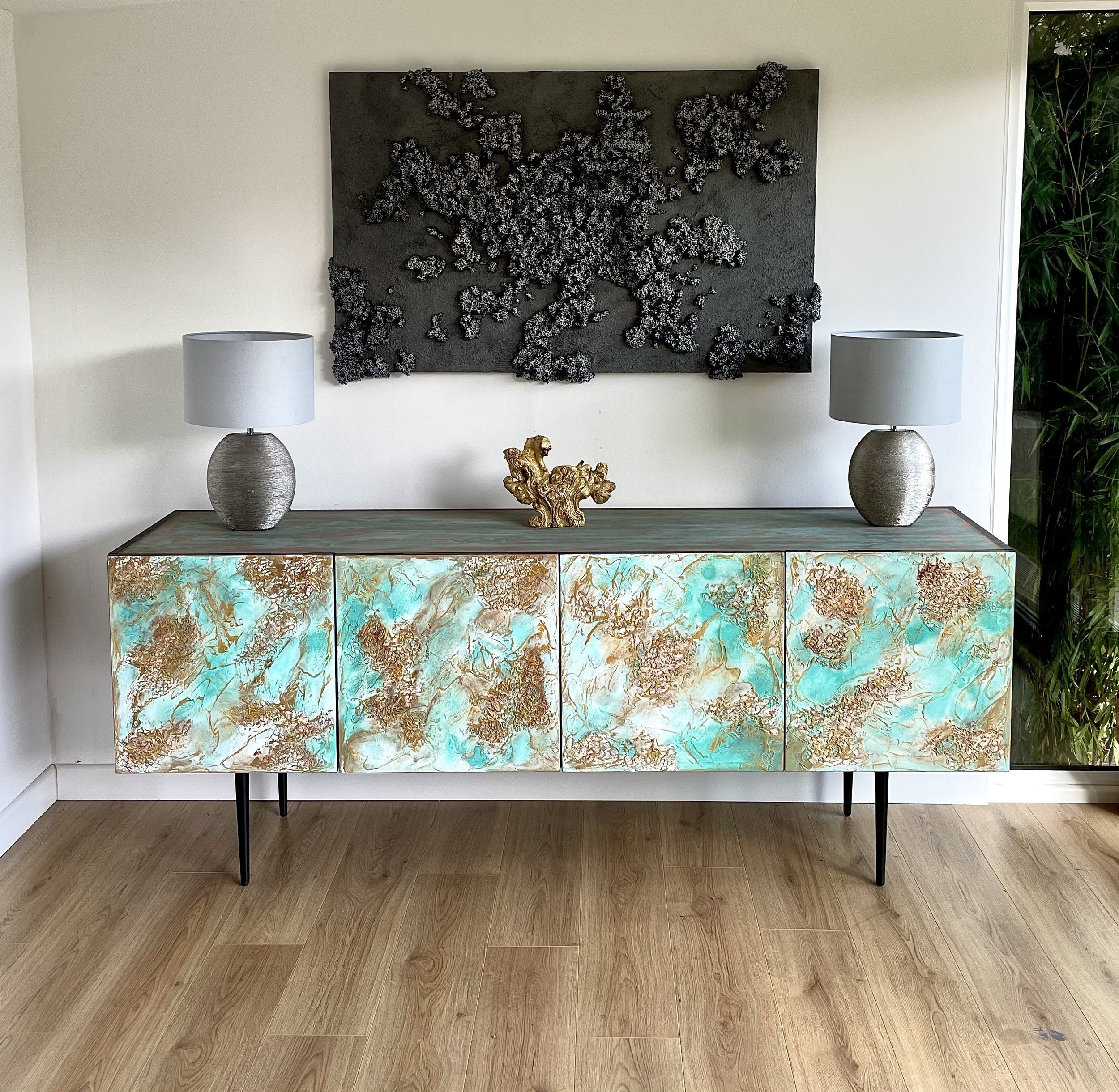 Large sideboard with cone black straight feet. Doors are textured and finished in combination of white, turquoise and copper.