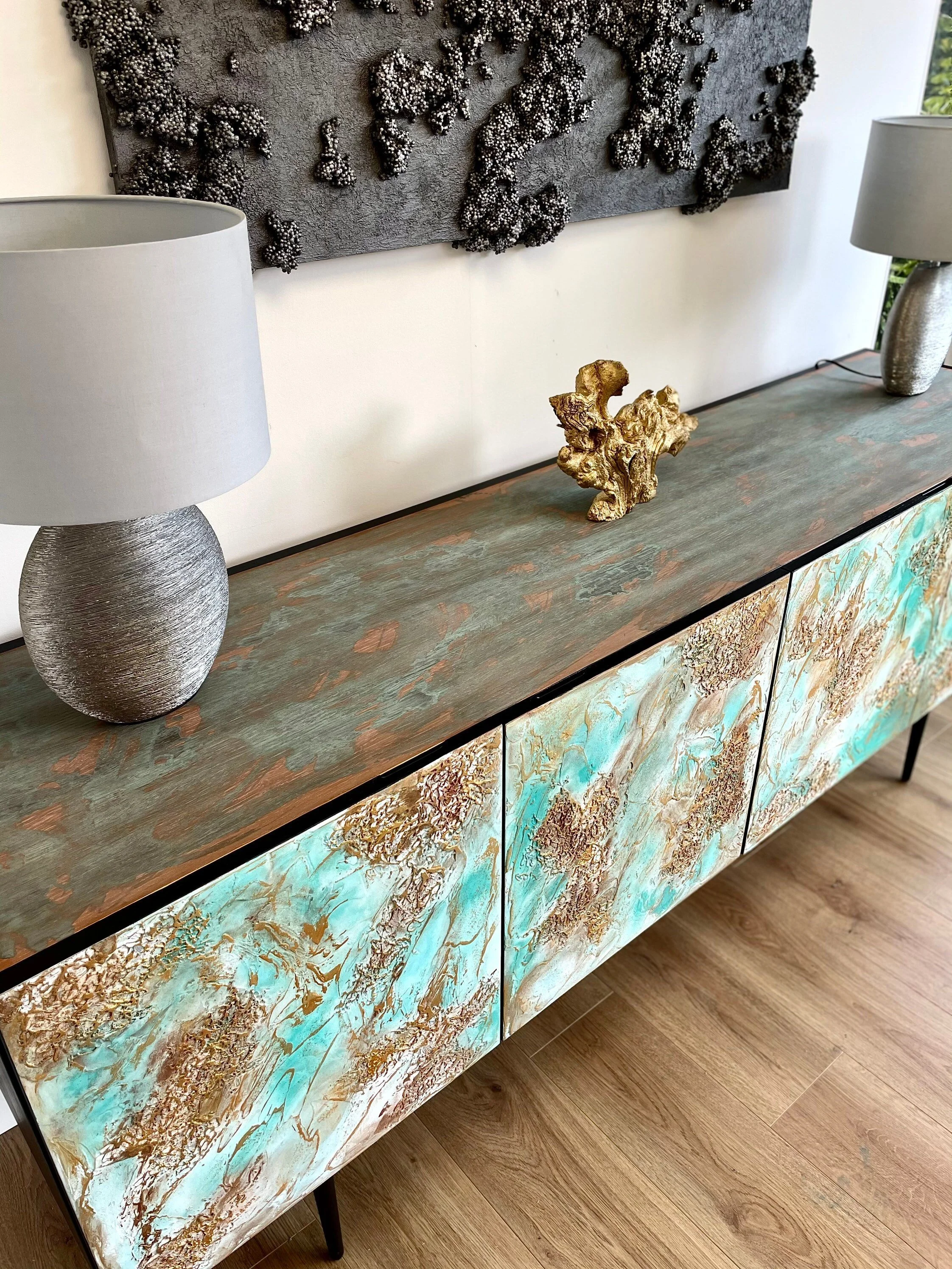 A bespoke sideboard with an artistic texture on the doors stands against a white wall.