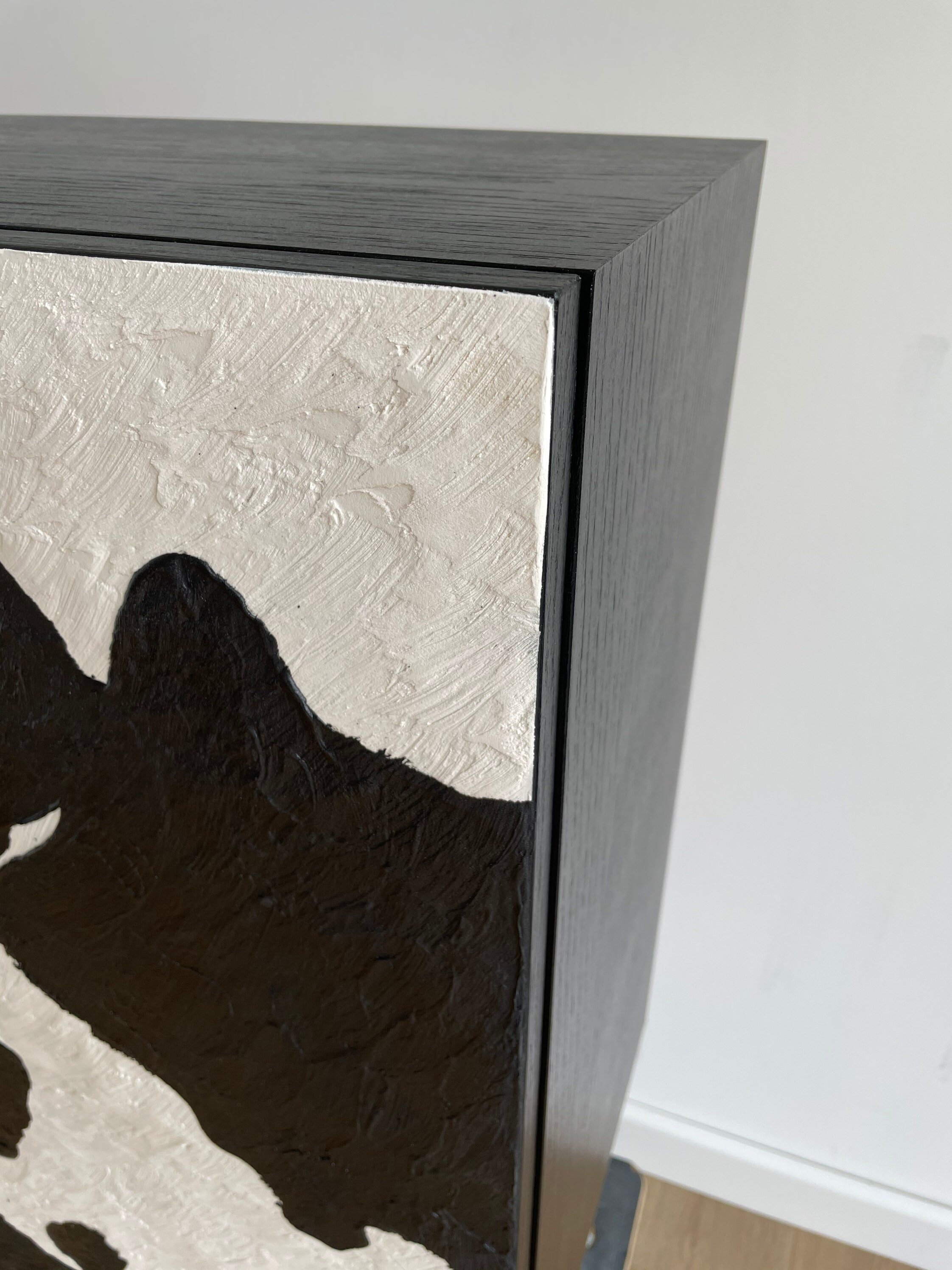 A close up of an custom made textured sideboard, featuring black and white, cowhide pattern.