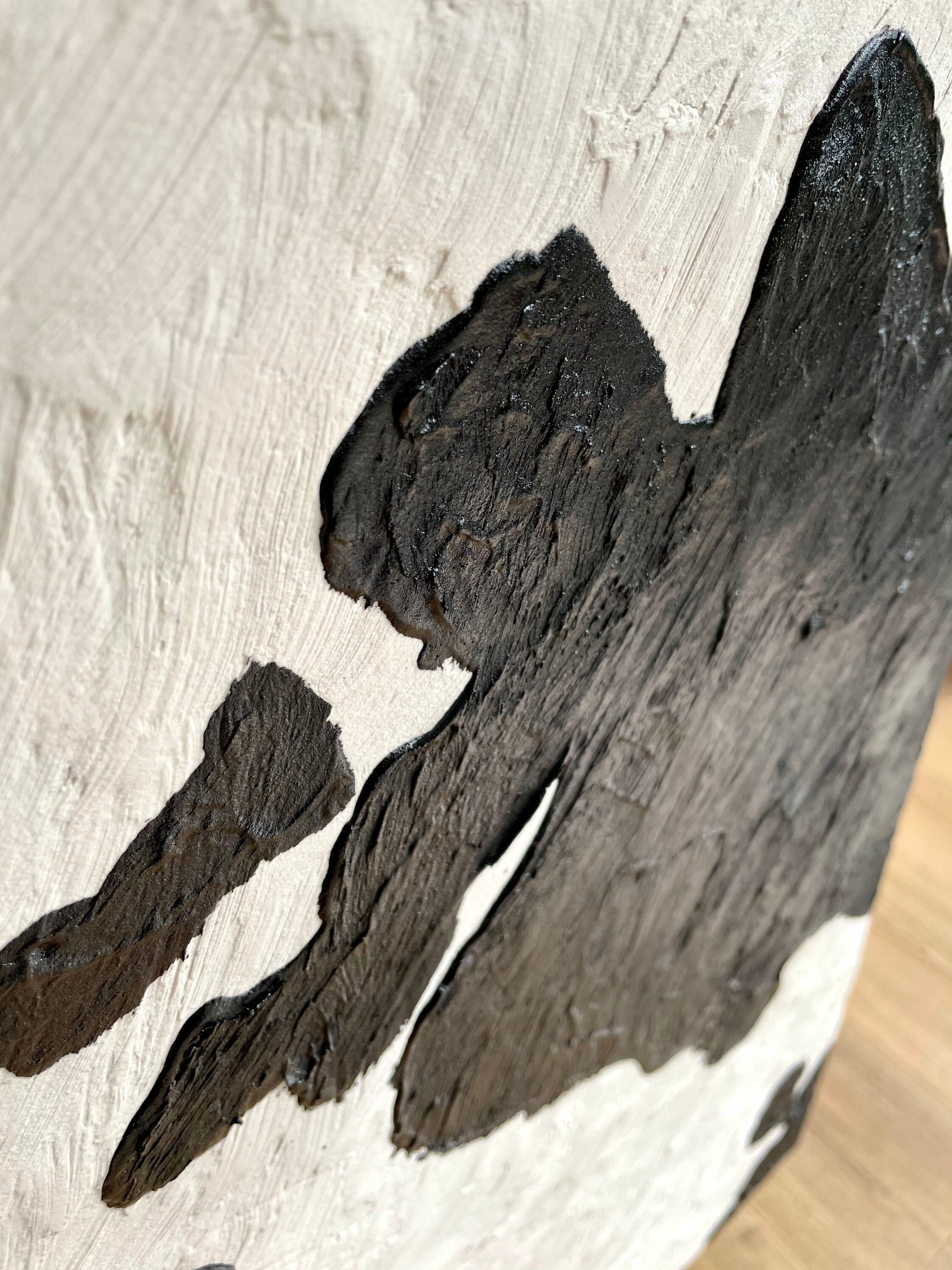 Close-up of a black and white cow pattern on a textured surface. A custom-made sideboard perfectly complements this modern and artistic ambiance.