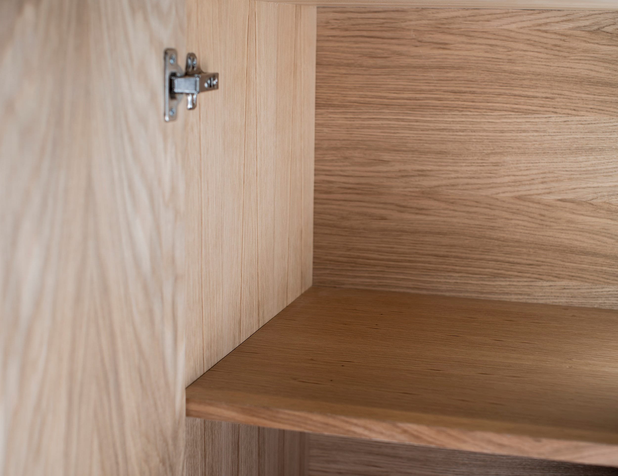 Sideboard interior in Oak wood finish, featuring one removable shelf.