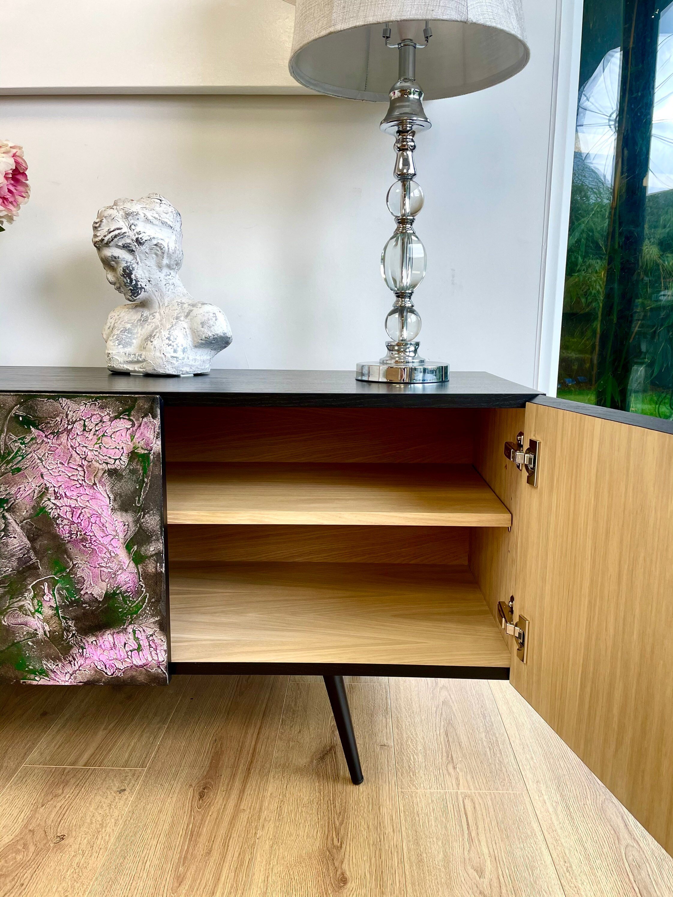 Modern black and pink, textured sideboard with open doors, displaying an Oak interior with one shelf.