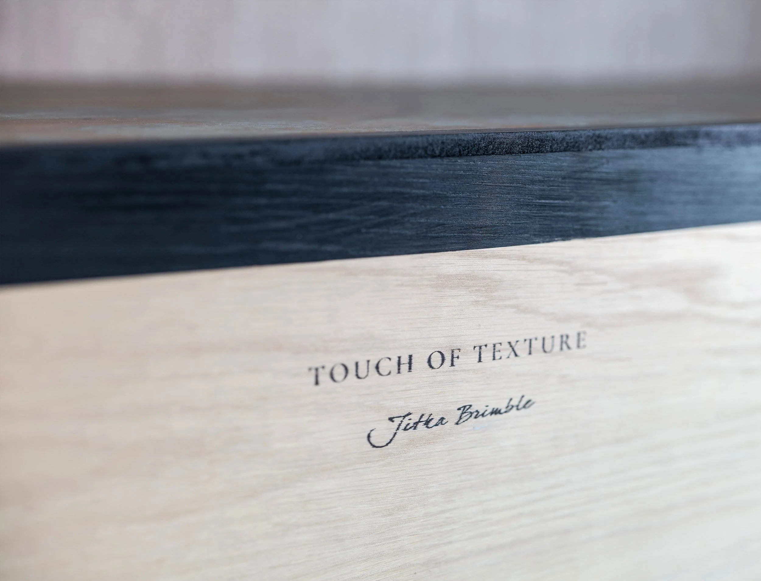 The words TOUCH OF TEXTURE and Jitka Brimble are printed on the light section of wooden back of a custom made sidebaord.