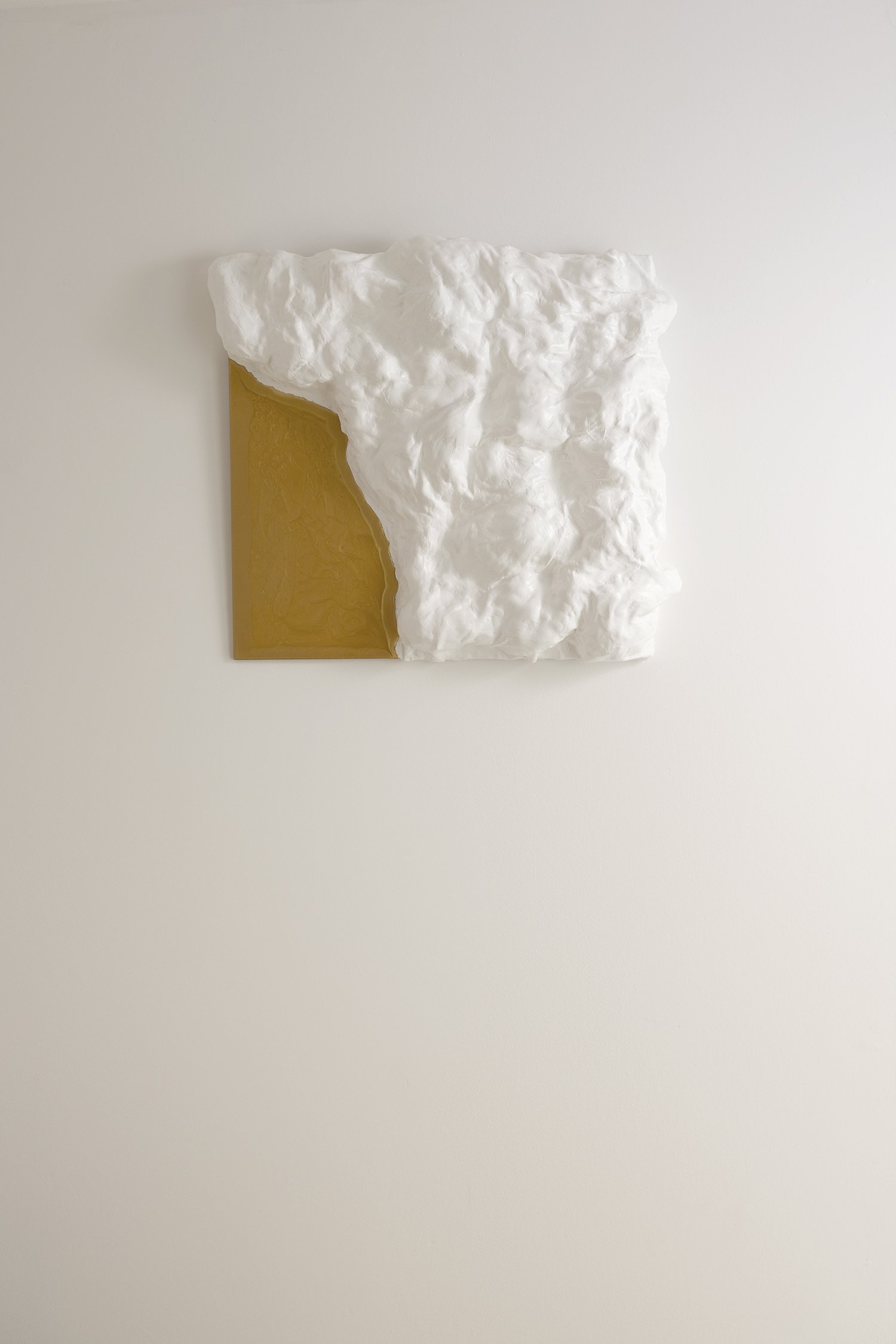 Textured art on the wall. Its interplay of white and gold brings a sense of movement and quiet luxury to any interior.