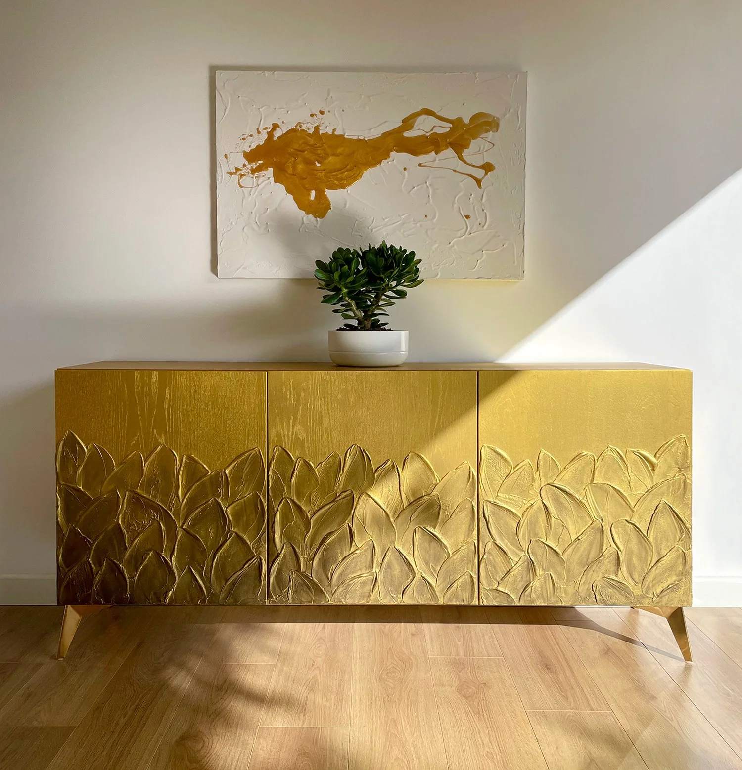 "Antiqued Foliage" high end bespoke gold furniture UK: A front-facing view of the 3-door gold sideboard showing the split-texture design.