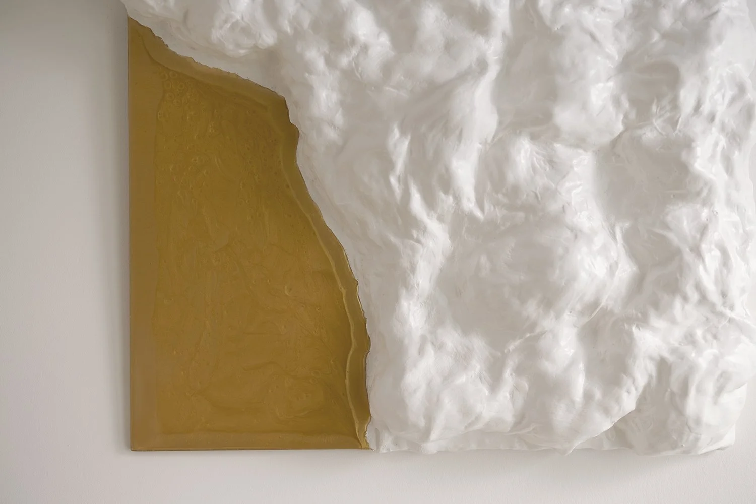 Sculptural wall artwork. Its flowing white surface, accented with gold, brings a sense of movement and luxurious sustainability.