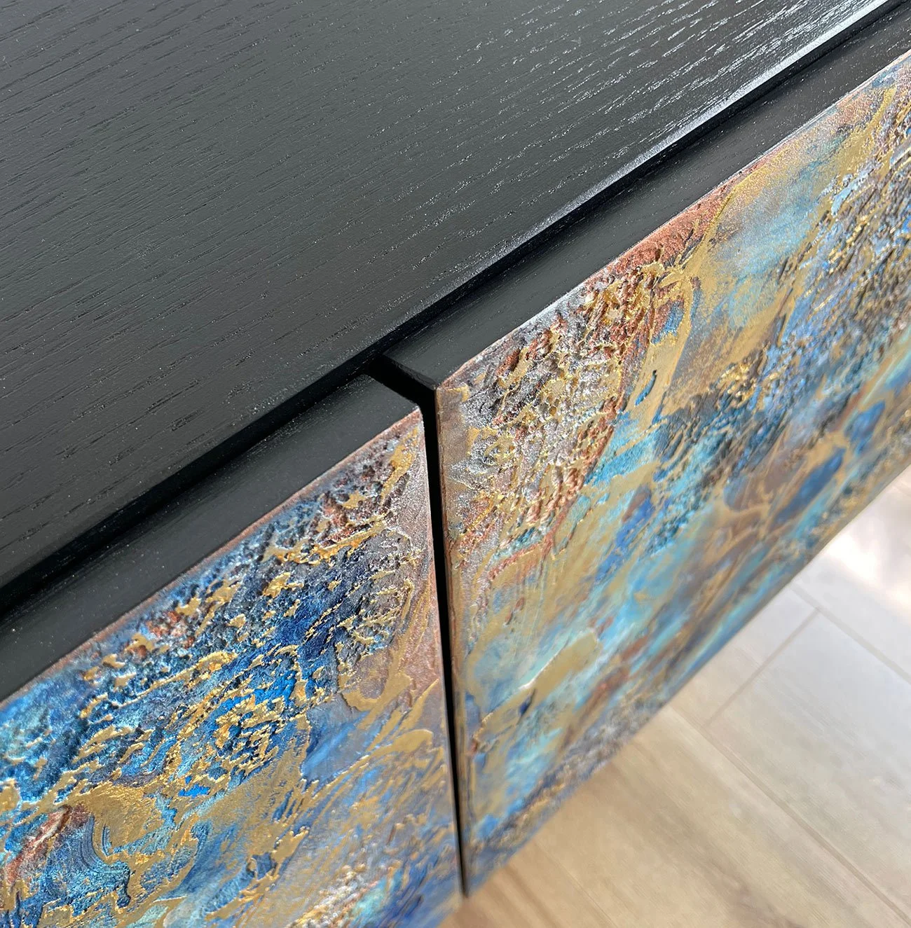 Macro shot of the Midnight Galaxy sideboard showcasing the precision-crafted mitred top edges, where the dark sleek top meets the hand-textured blue and gold doors for a seamless, high-end finish.