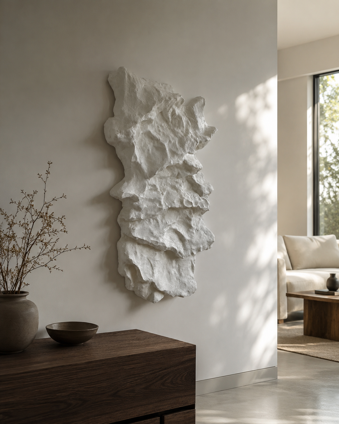 Sculptural white wall art resembling a a stone like finish,  hanging in modern situ.