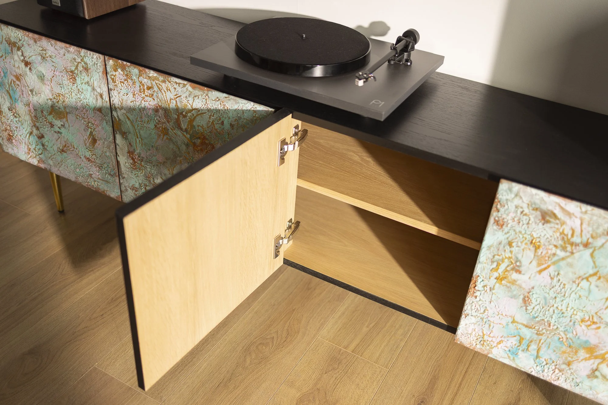 Textured sideboard featuring doors in green, copper, gold, and pale pink.