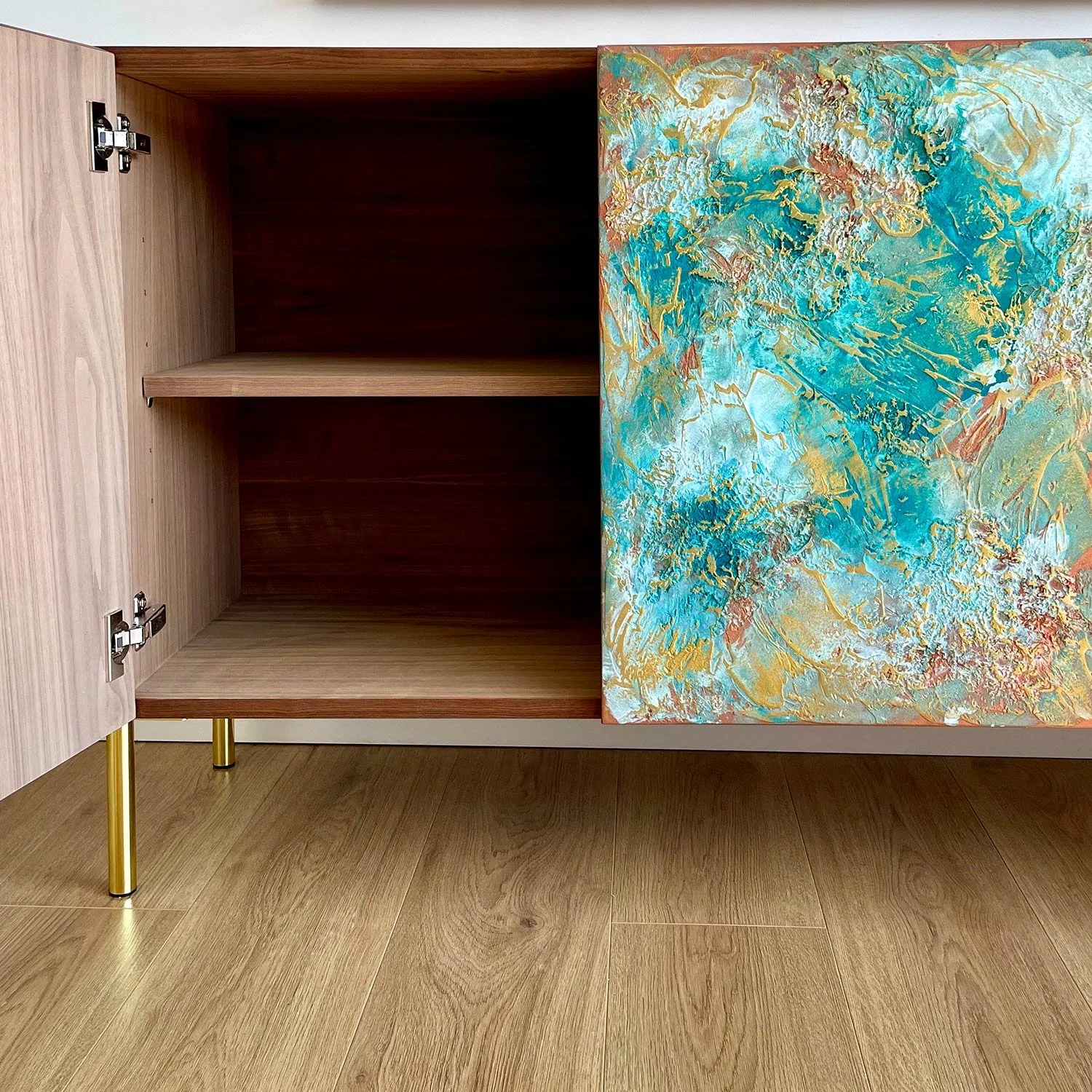 Sideboard with gold straight feet, one door open revealing an oak interior with a single shelf.