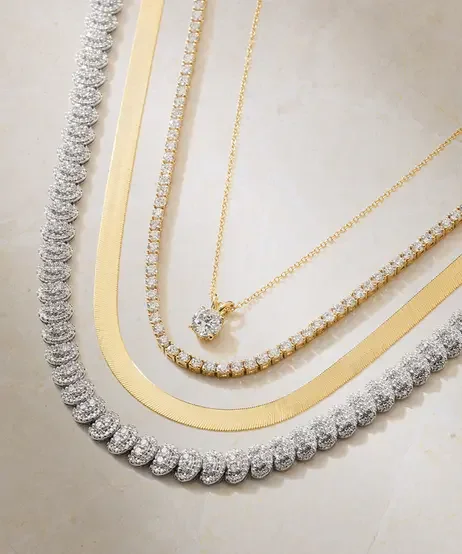 A_diamond_pendant,_and_tennis_necklace_stacked.webp