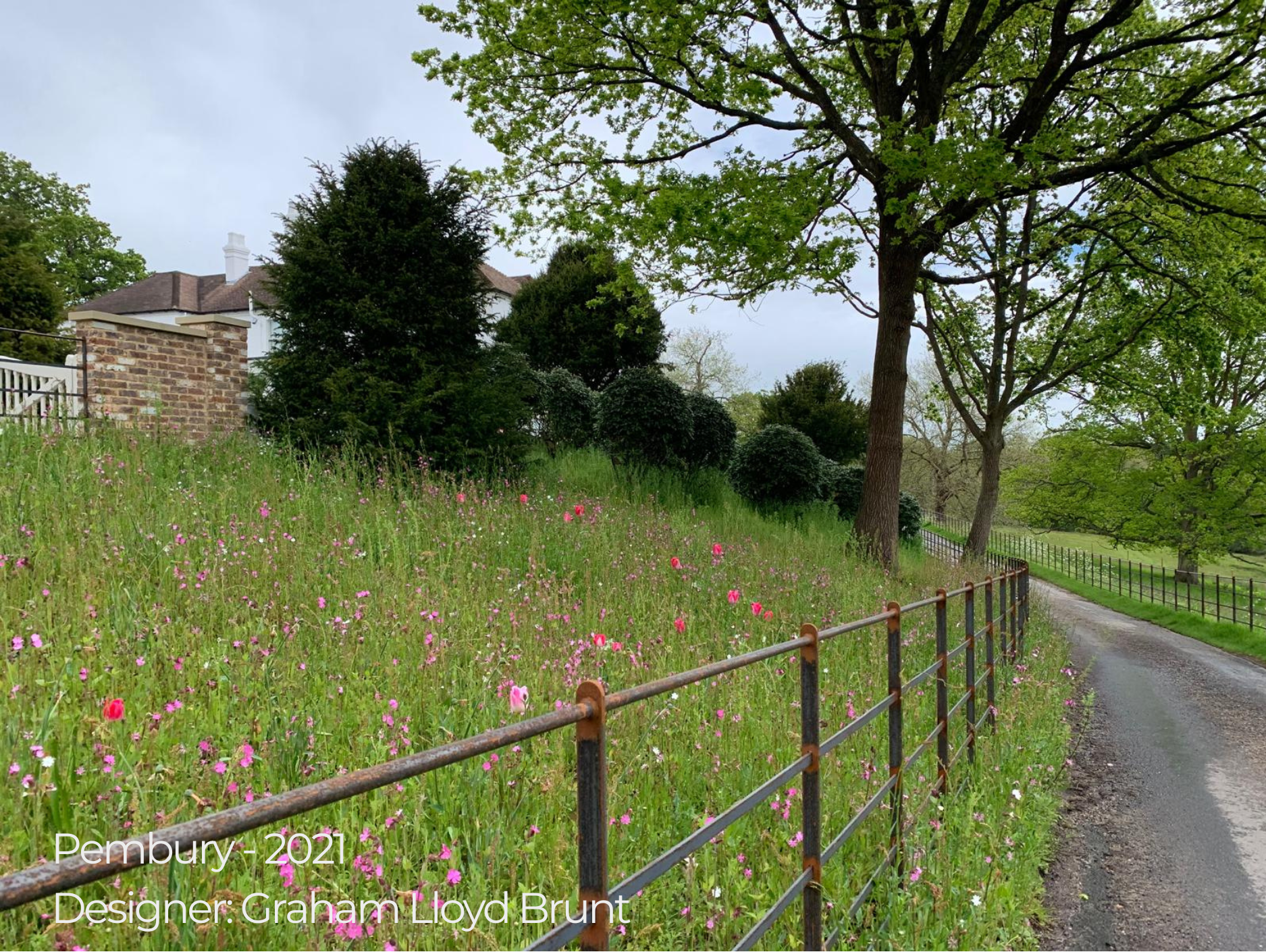 meadow garden enclosed behind a fence on a private drive way