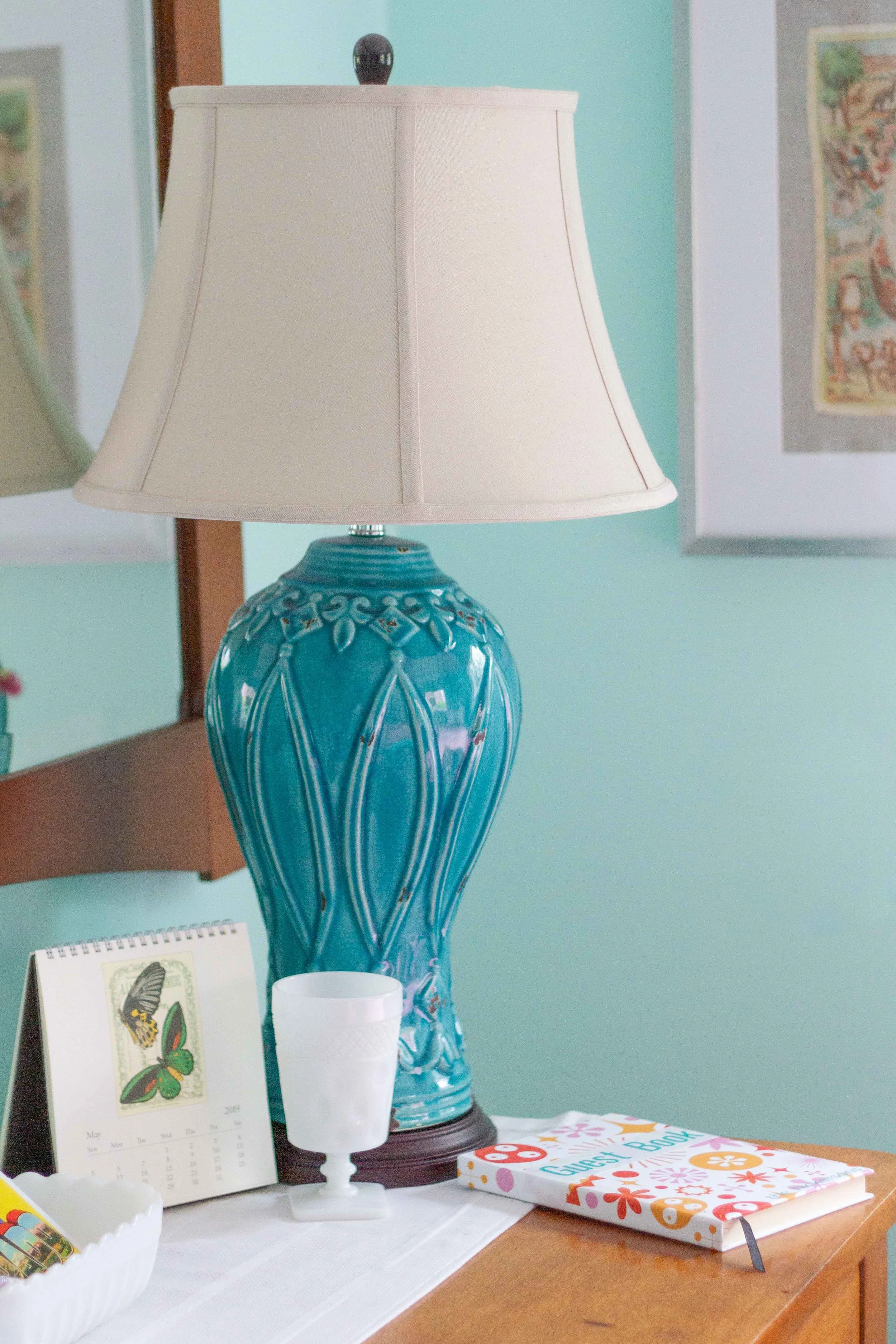A turquoise porcelain lamp with a classic shade works well on the antique dresser.
