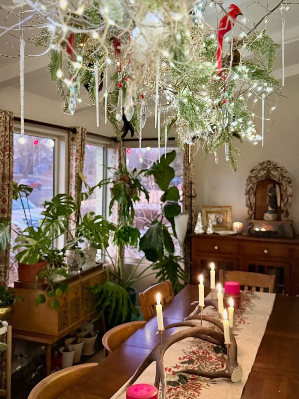 Bringing the garden inside for the Christmas season&hellip; greens hung on the branch chandelier which has been festooned with a flock of colorful birds and is dripping with crystal and icicles. The candelabra, made from shed elk antlers, brings cozy