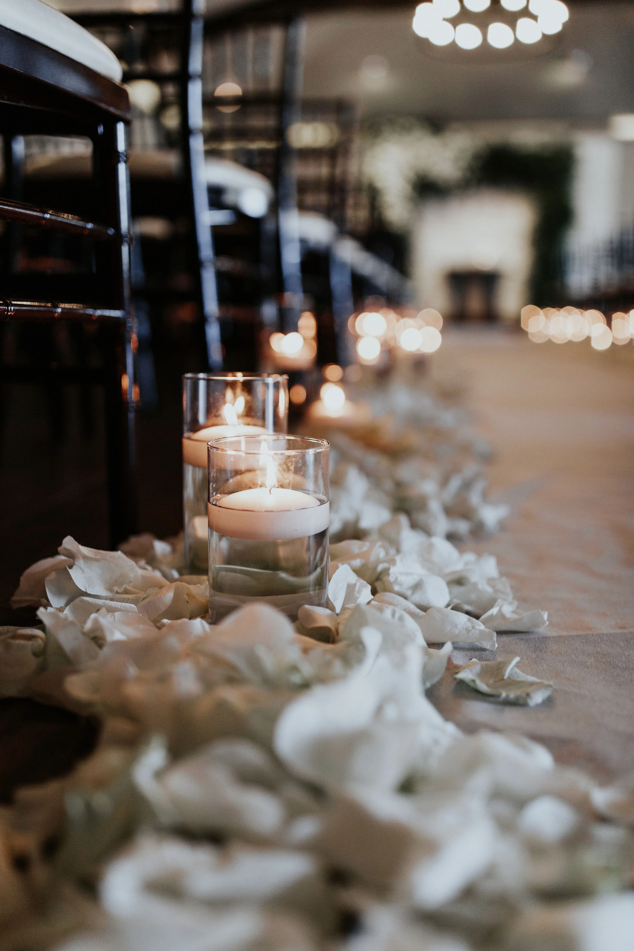 Let’s just take a minute to truly appreciate the ceremony site. Originally we were going to be outside but as weather would have it, plans change, but we are not mad about it. We love how the room turned out. The aisle was double lined in cylinders, floating candles, and moonstone rose petals.