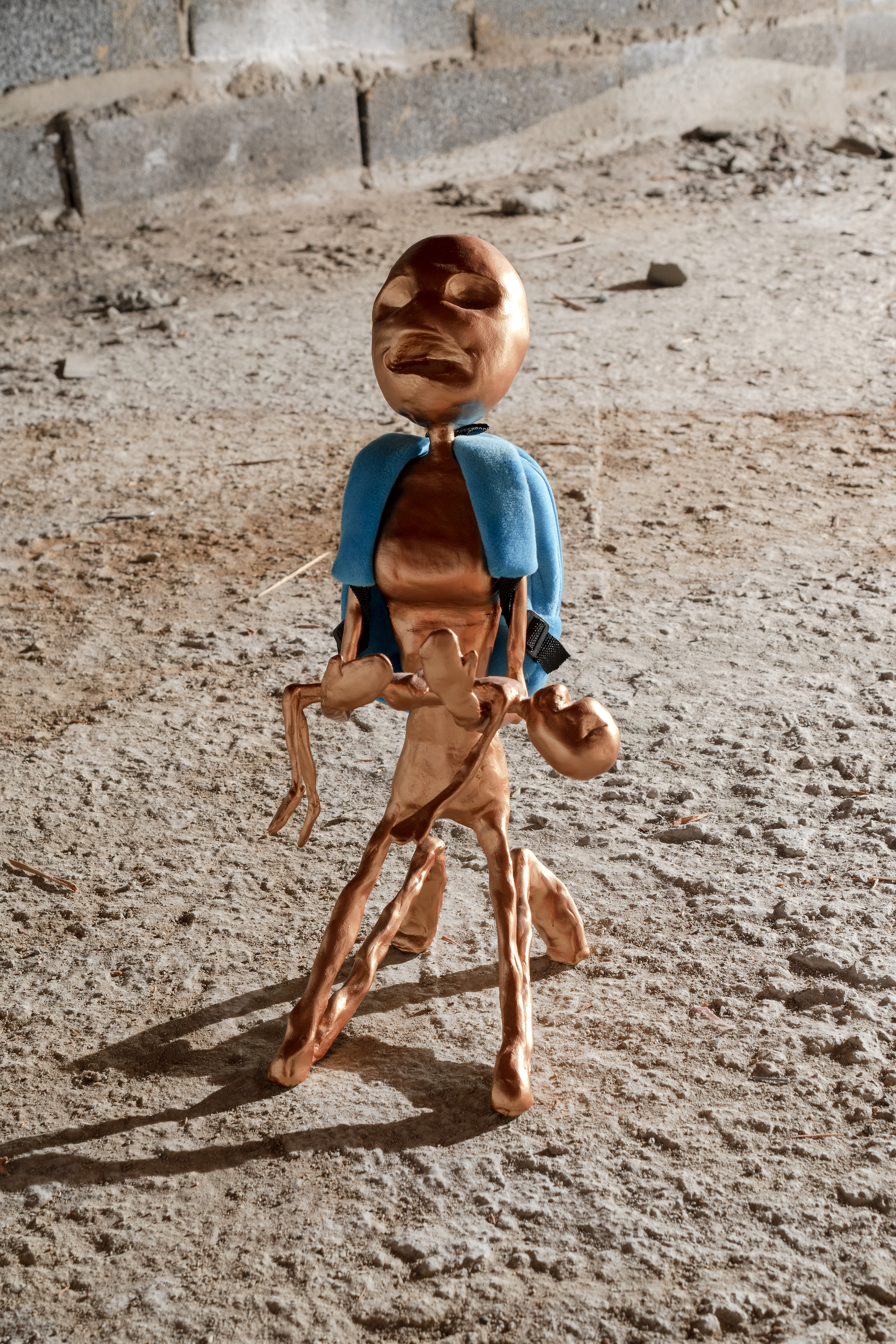 Deidre Sargent,  two standing aliens —&gt;Cinema mode (Neveda Orange Zetas) / Kneeling alien with toddler—&gt;   Earth’s Violent History , 2017, resin putty, wire, foam, miniature backpacks, 21”x8”x8 / 15”x9”x7” 